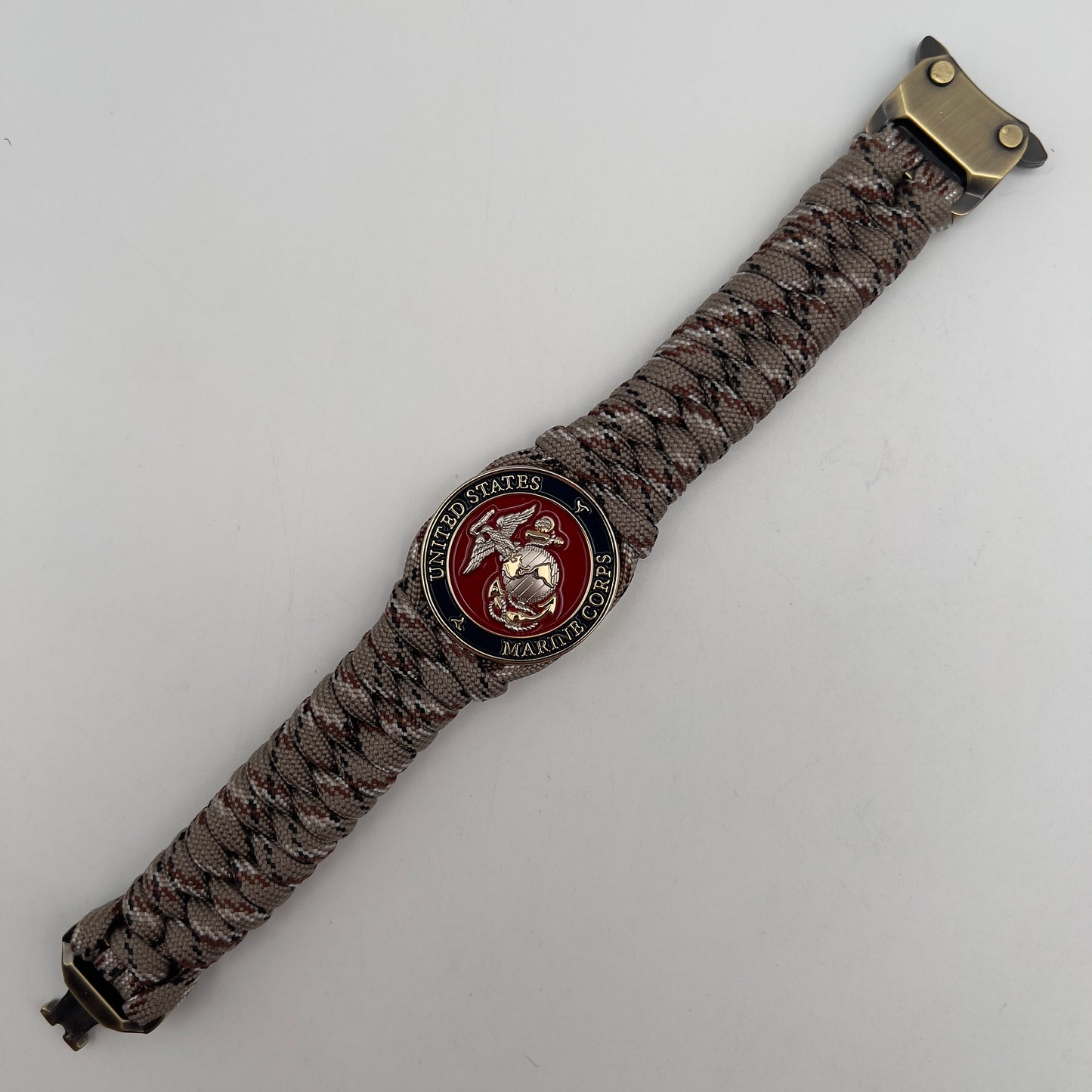 Thick and comfortable braided United States Marine Corps bracelet featuring a 24K gold and silver plated USMC officer Eagle Globe and Anchor medallion, a Cobra style tactical buckle and woven with Desert Camo paracord.