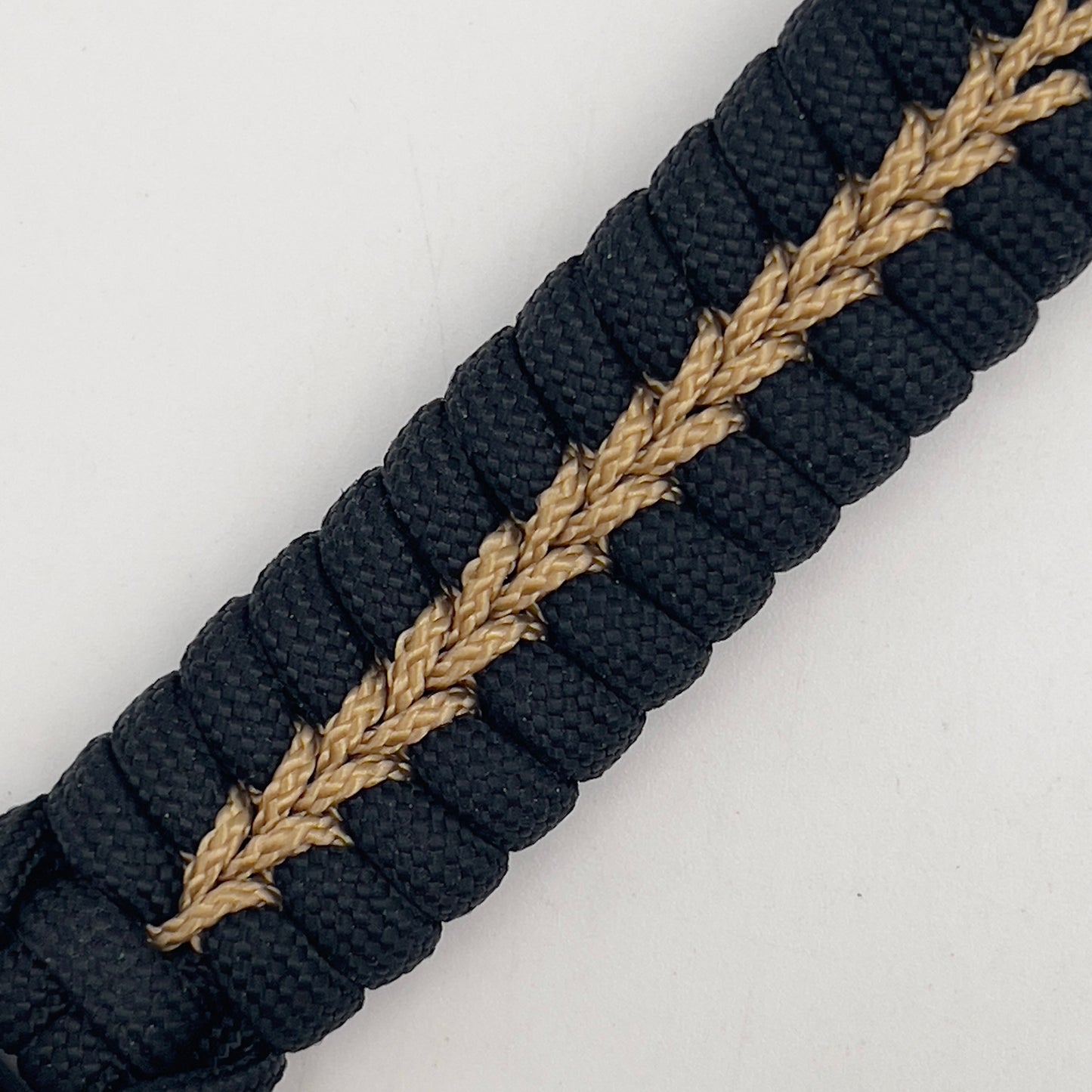 Thick, semi-rigid and comfortable braided United States Marine Corps bracelet featuring a 24K gold and silver plated USMC officer Eagle Globe and Anchor medallion, a black Cobra style tactical buckle and woven with black 550 and gold micro paracord.