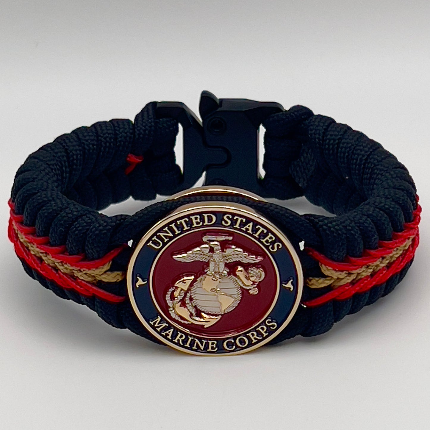 Thick, semi-rigid and comfortable braided United States Marine Corps bracelet featuring a 24K gold and silver plated USMC officer Eagle Globe and Anchor medallion, a black Cobra style tactical buckle and woven with black 550, Imperial red and gold micro paracord.