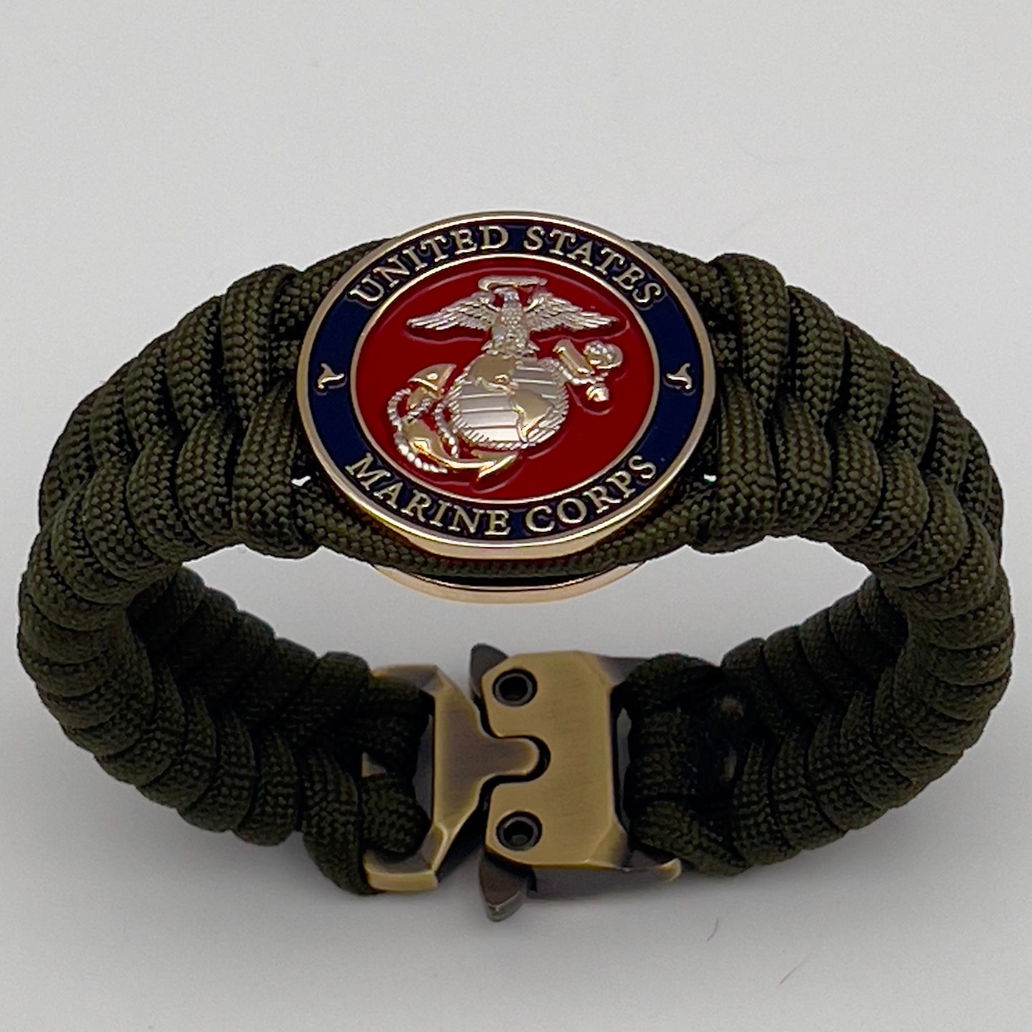 Thick, semi-rigid and comfortable braided United States Marine Corps bracelet featuring a 24K gold and silver plated USMC officer Eagle Globe and Anchor medallion, a gold Cobra style tactical buckle and woven with olive drab 550 paracord.