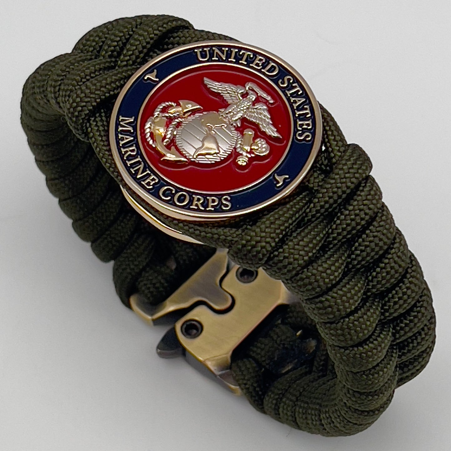 Thick, semi-rigid and comfortable braided United States Marine Corps bracelet featuring a 24K gold and silver plated USMC officer Eagle Globe and Anchor medallion, a gold Cobra style tactical buckle and woven with olive drab 550 paracord.
