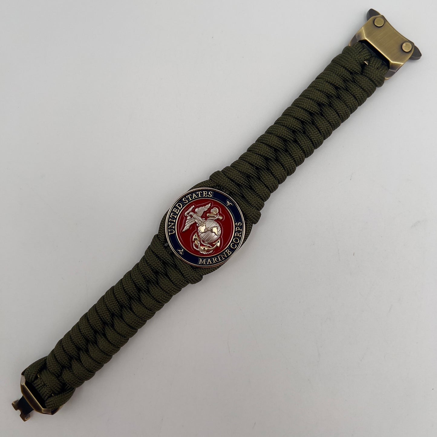 Thick, semi-rigid and comfortable braided United States Marine Corps bracelet featuring a 24K gold and silver plated USMC officer Eagle Globe and Anchor medallion, a gold Cobra style tactical buckle and woven with olive drab 550 paracord.