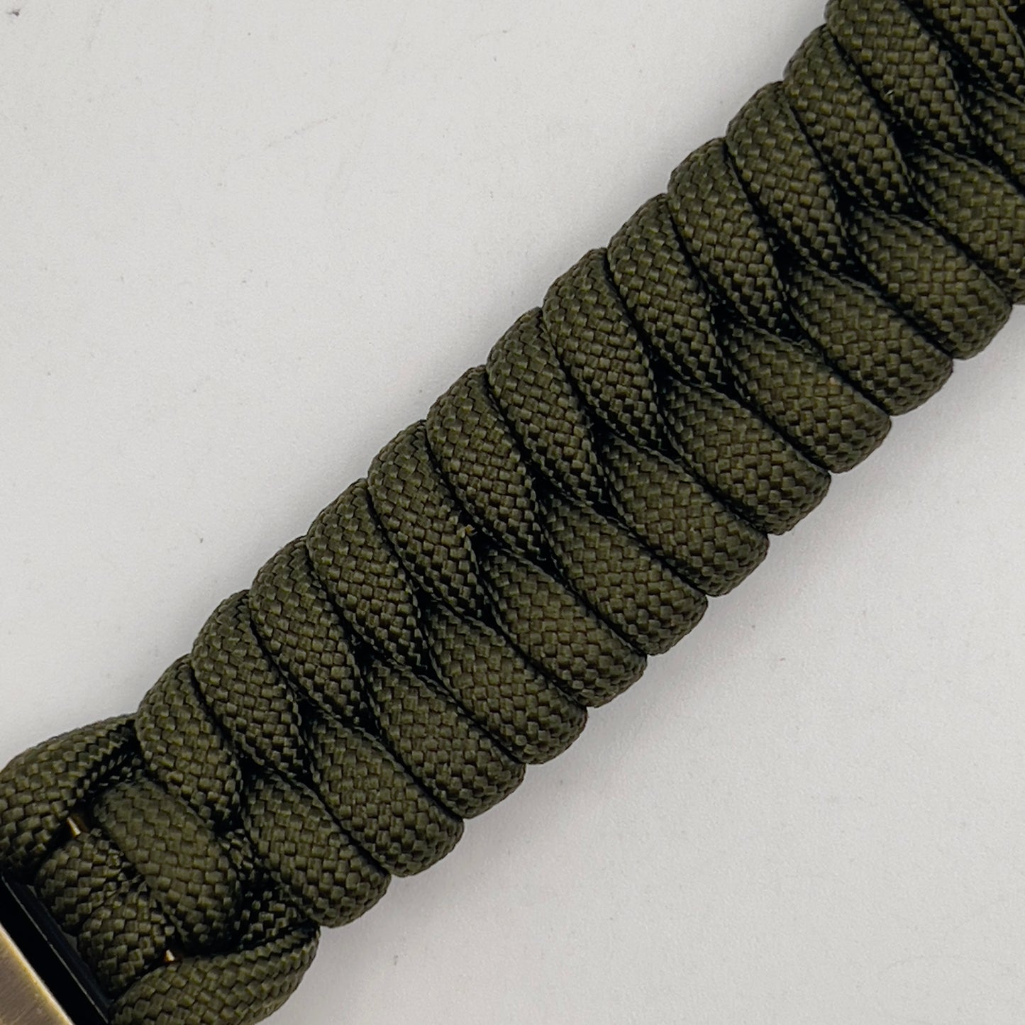 Thick, semi-rigid and comfortable braided United States Marine Corps bracelet featuring a 24K gold and silver plated USMC officer Eagle Globe and Anchor medallion, a gold Cobra style tactical buckle and woven with olive drab 550 paracord.