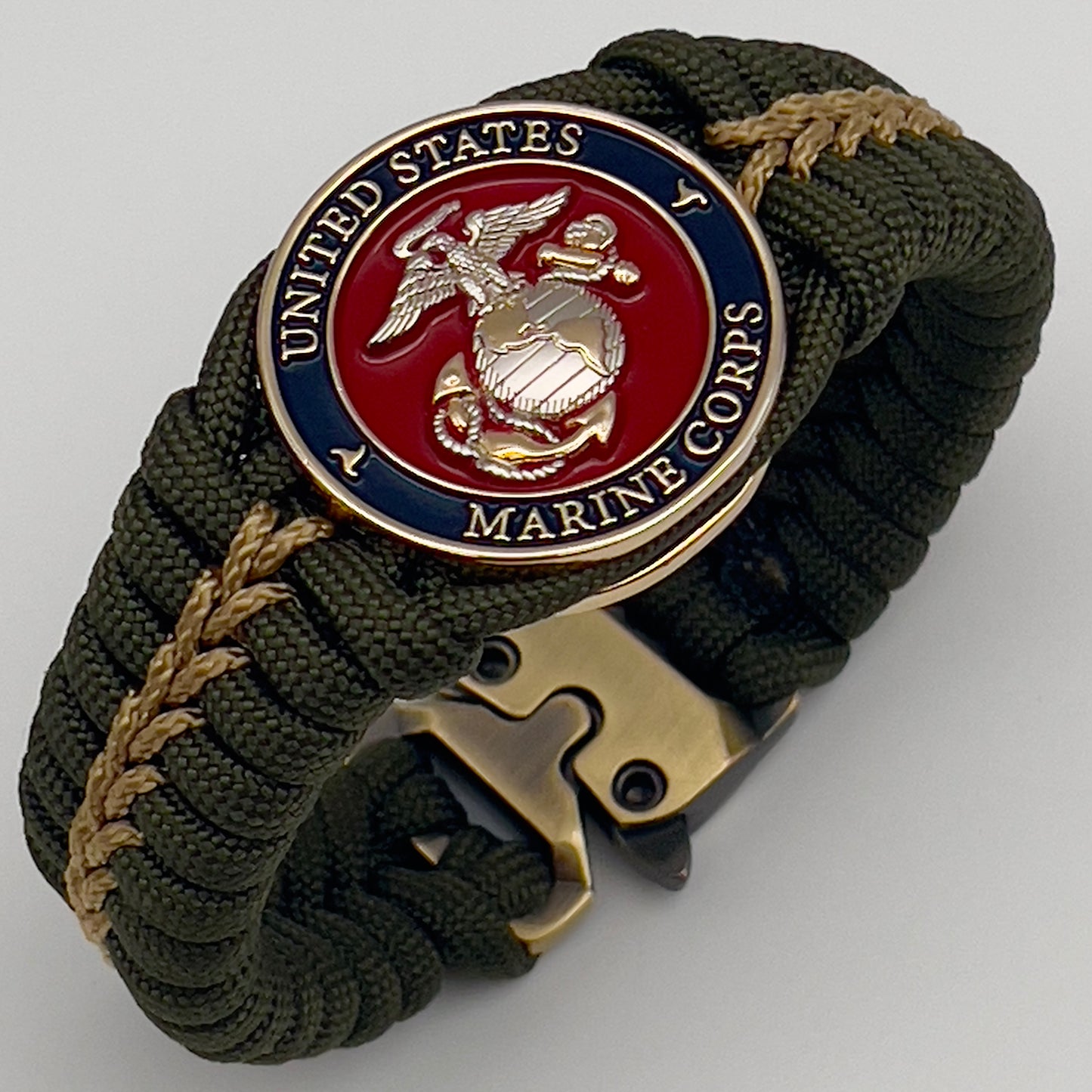 Thick, semi-rigid and comfortable braided United States Marine Corps bracelet featuring a 24K gold and silver plated USMC officer Eagle Globe and Anchor medallion, a gold Cobra style tactical buckle and woven with olive drab 550 and gold micro paracord.