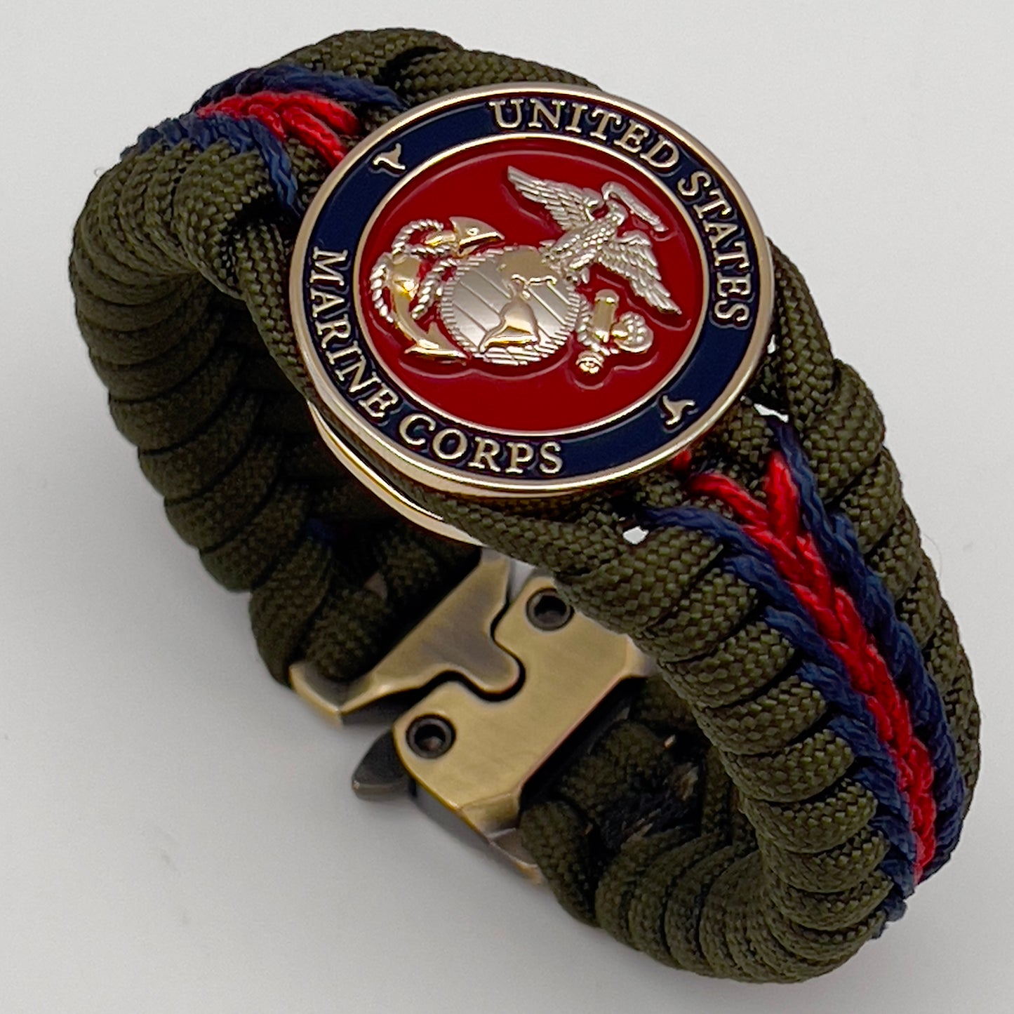 Thick, semi-rigid and comfortable braided United States Marine Corps bracelet featuring a 24K gold and silver plated USMC officer Eagle Globe and Anchor medallion, a gold Cobra style tactical buckle and woven with olive drab 550 and Imperial red and gold micro paracord.