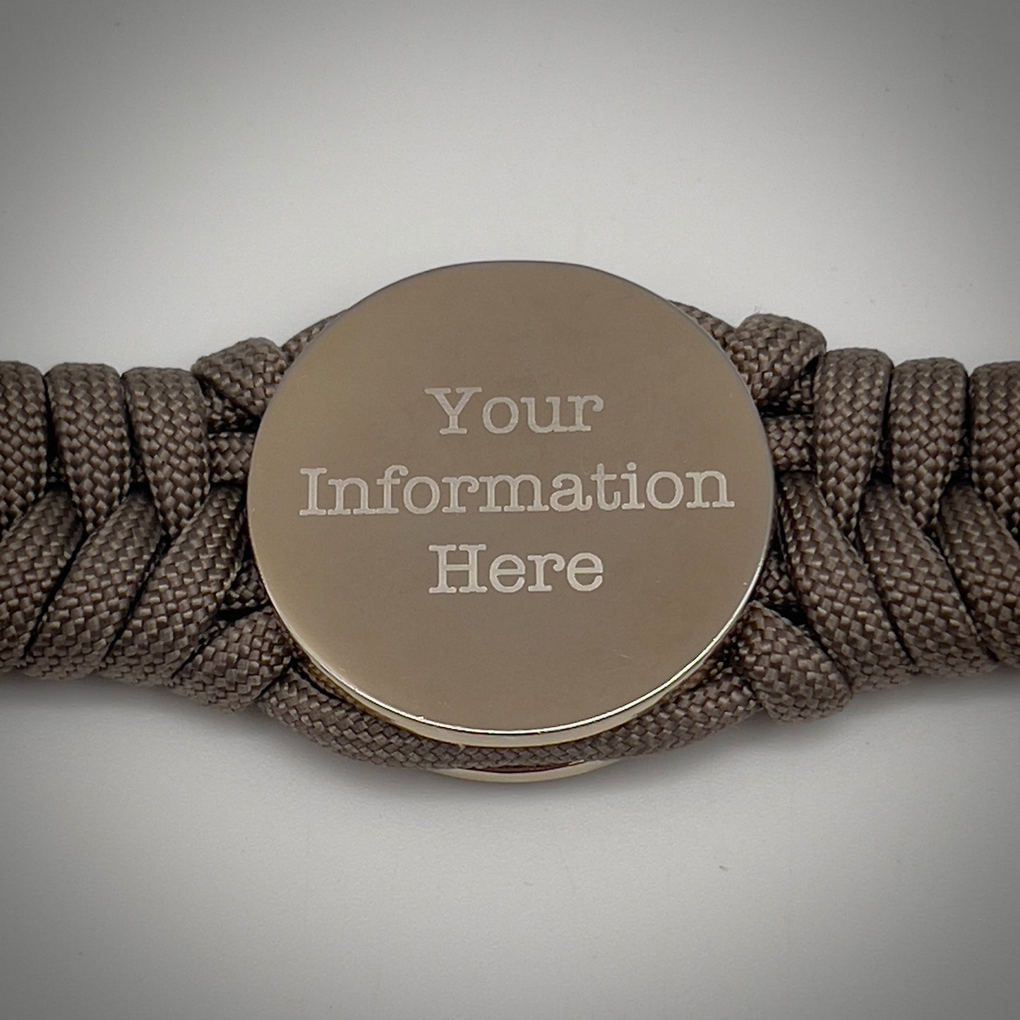 Thick, semi-rigid and comfortable braided United States Marine Corps bracelet featuring a 24K gold and silver plated USMC officer Eagle Globe and Anchor medallion, a gold Cobra style tactical buckle and woven with tan 550 paracord.