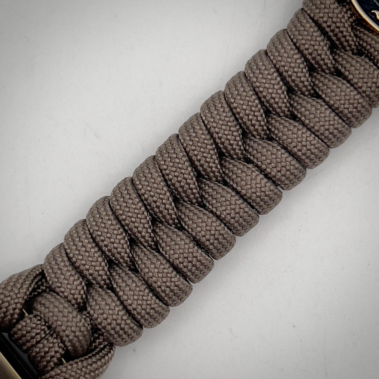 Thick, semi-rigid and comfortable braided United States Marine Corps bracelet featuring a 24K gold and silver plated USMC officer Eagle Globe and Anchor medallion, a gold Cobra style tactical buckle and woven with tan 550 paracord.