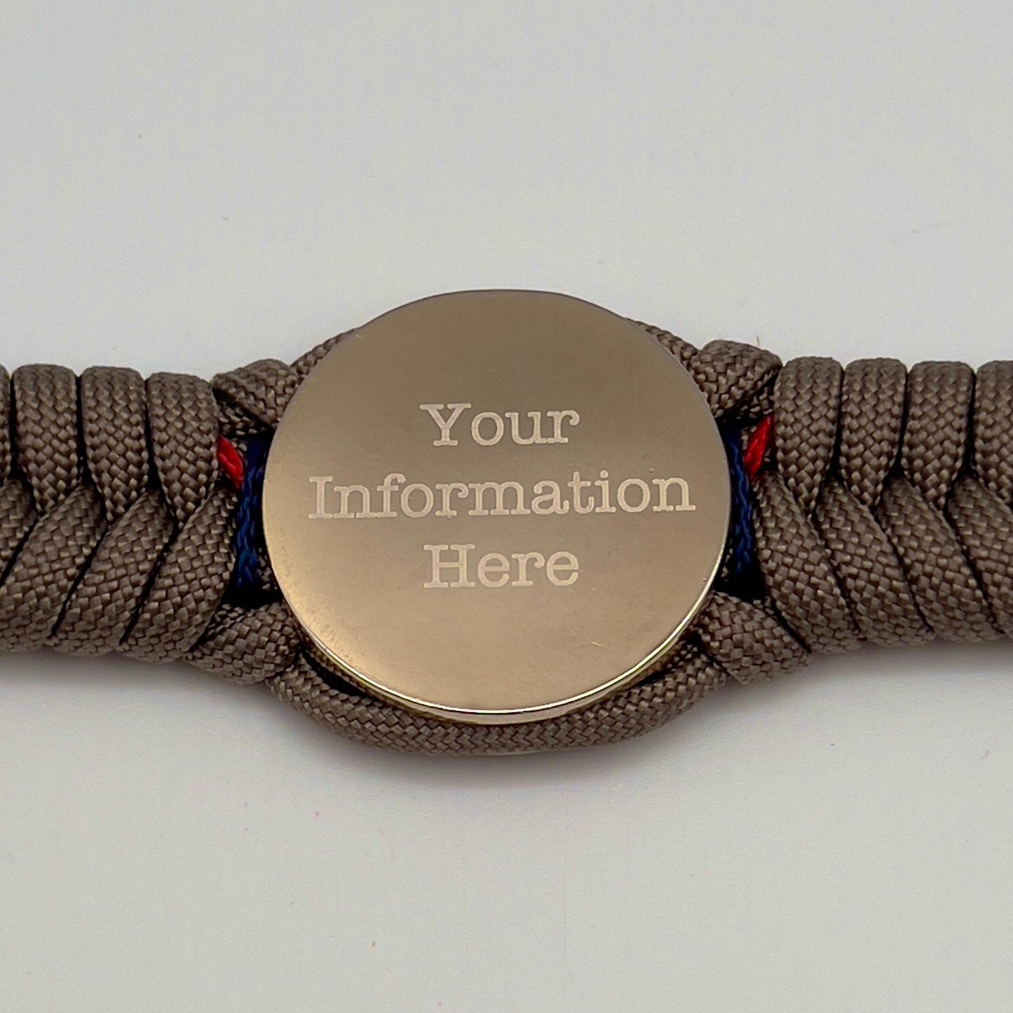 Thick, semi-rigid and comfortable braided United States Marine Corps bracelet featuring a 24K gold and silver plated USMC officer Eagle Globe and Anchor medallion, a gold Cobra style tactical buckle and woven with tan 550 paracord and Imperial red and gold micro cord.