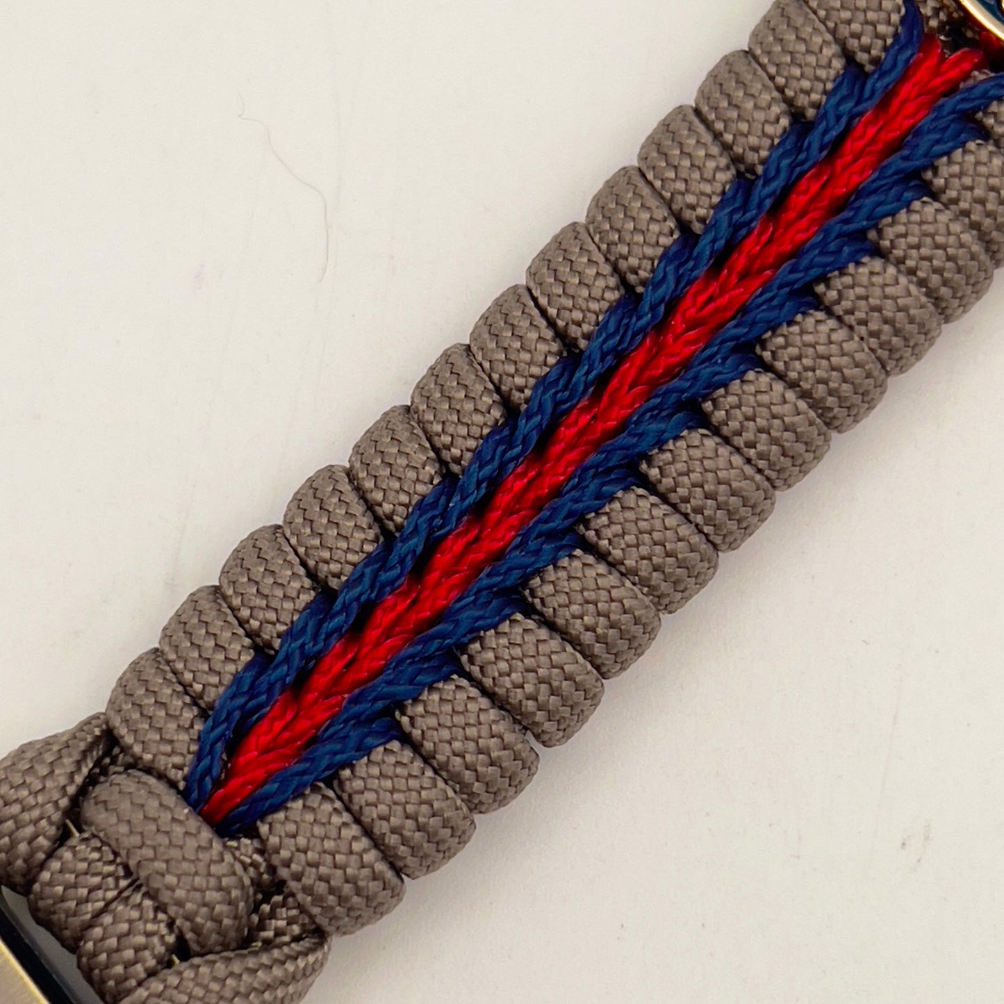 Thick, semi-rigid and comfortable braided United States Marine Corps bracelet featuring a 24K gold and silver plated USMC officer Eagle Globe and Anchor medallion, a gold Cobra style tactical buckle and woven with tan 550 paracord and Imperial red and gold micro cord.