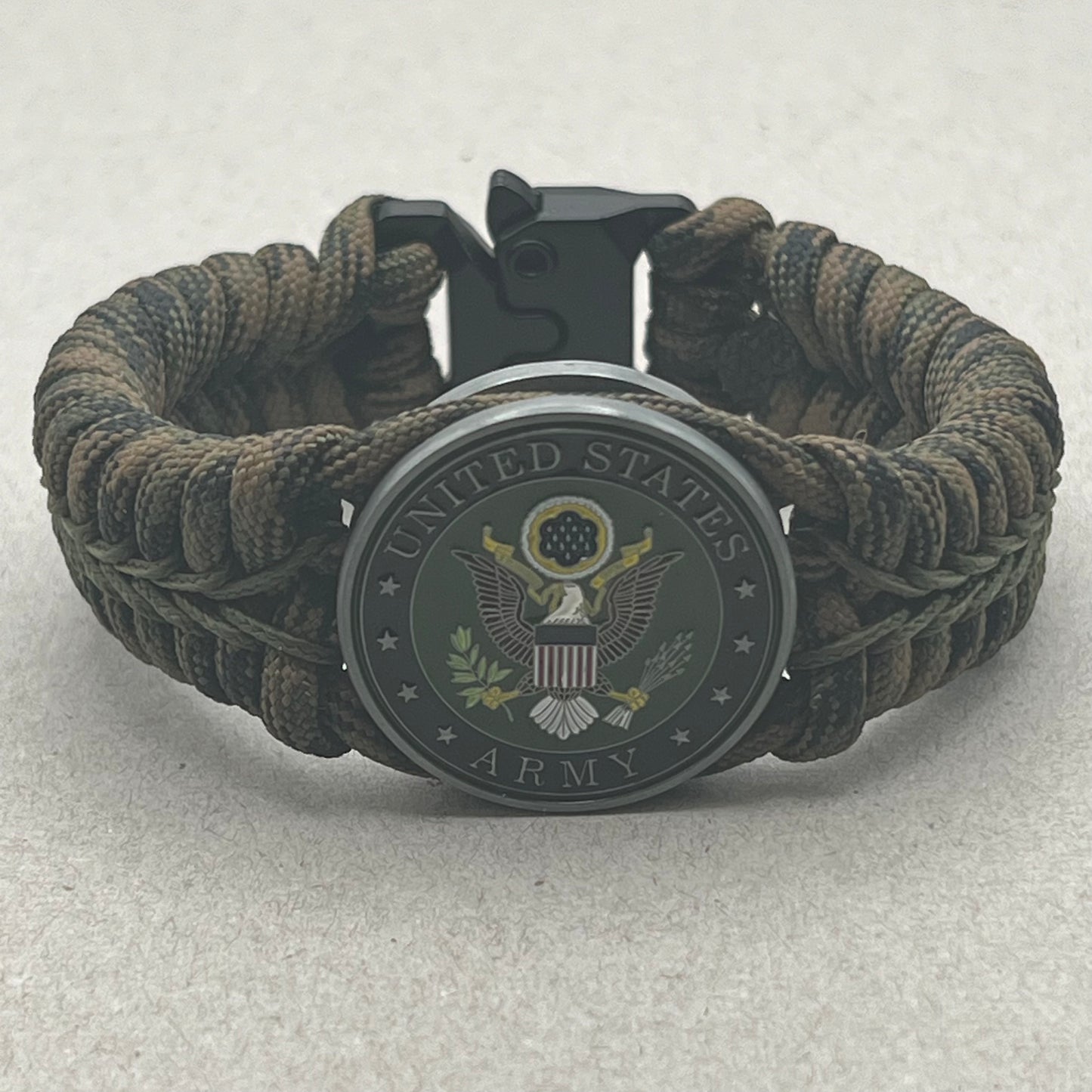 Thick, narrow, rigid and comfortable braided United States Army bracelet featuring an antique silver plated baked enamel hand painted US Army medallion, a black Cobra style tactical buckle and woven with Woodland Camo 550 paracord and Olive Drab micro cord.