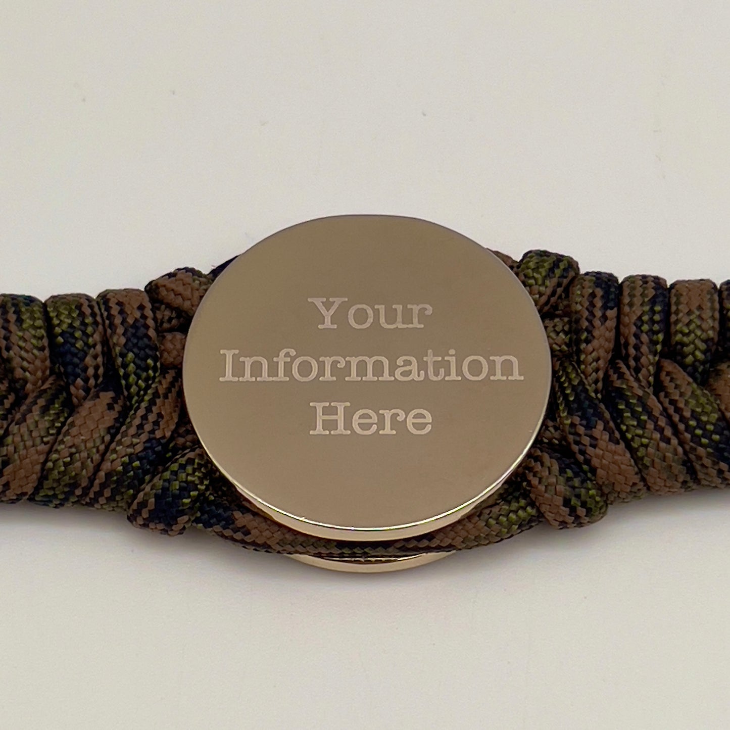 Thick, semi-rigid and comfortable braided United States Marine Corps bracelet featuring a 24K gold and silver plated USMC officer Eagle Globe and Anchor medallion, a gold Cobra style tactical buckle and woven with Woodland Camo 550 paracord.