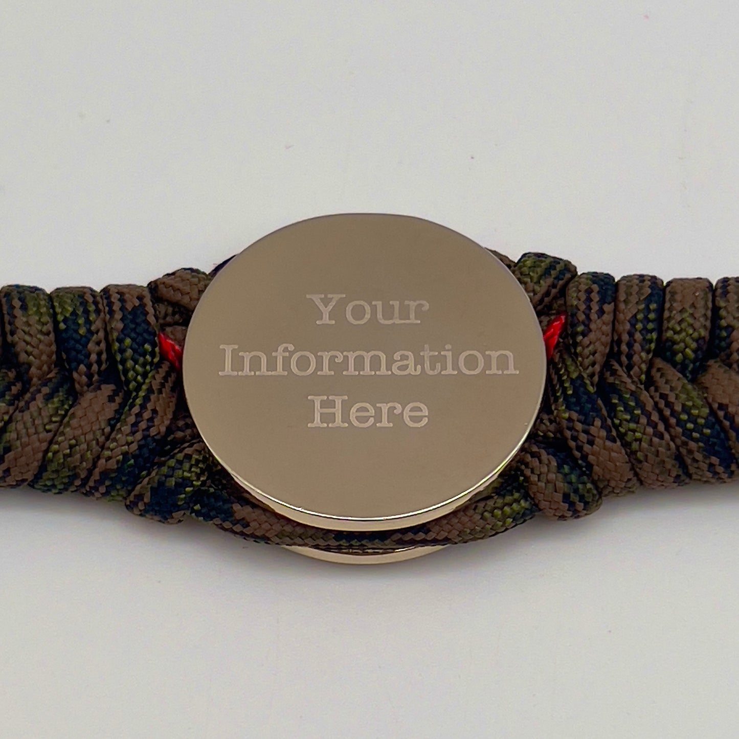 Thick, semi-rigid and comfortable braided United States Marine Corps bracelet featuring a 24K gold and silver plated USMC officer Eagle Globe and Anchor medallion, a gold Cobra style tactical buckle and woven with Woodland Camo 550 paracord and Imperial Red micro cord.