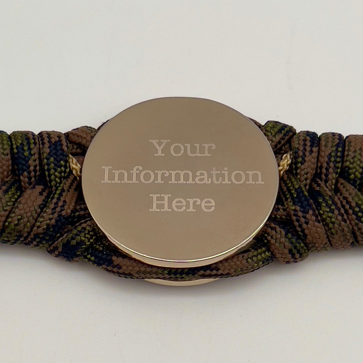 Thick, semi-rigid and comfortable braided United States Marine Corps bracelet featuring a 24K gold and silver plated USMC officer Eagle Globe and Anchor medallion, a gold Cobra style tactical buckle and woven with Woodland Camo 550 paracord and gold micro cord.