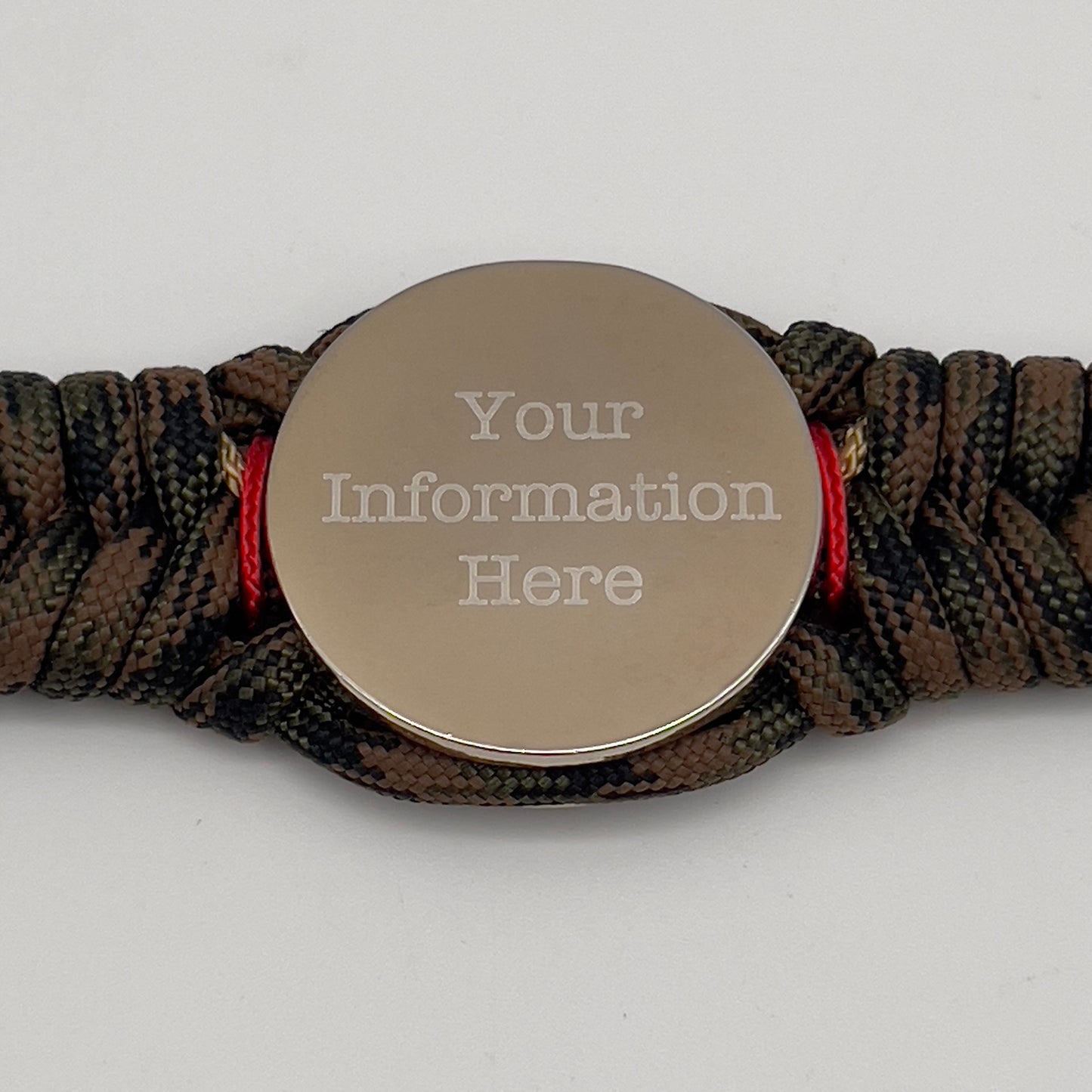 Thick, semi-rigid and comfortable braided United States Marine Corps bracelet featuring a 24K gold and silver plated USMC officer Eagle Globe and Anchor medallion, a gold Cobra style tactical buckle and woven with Woodland Camo 550 paracord and Imperial Red and gold micro cord.