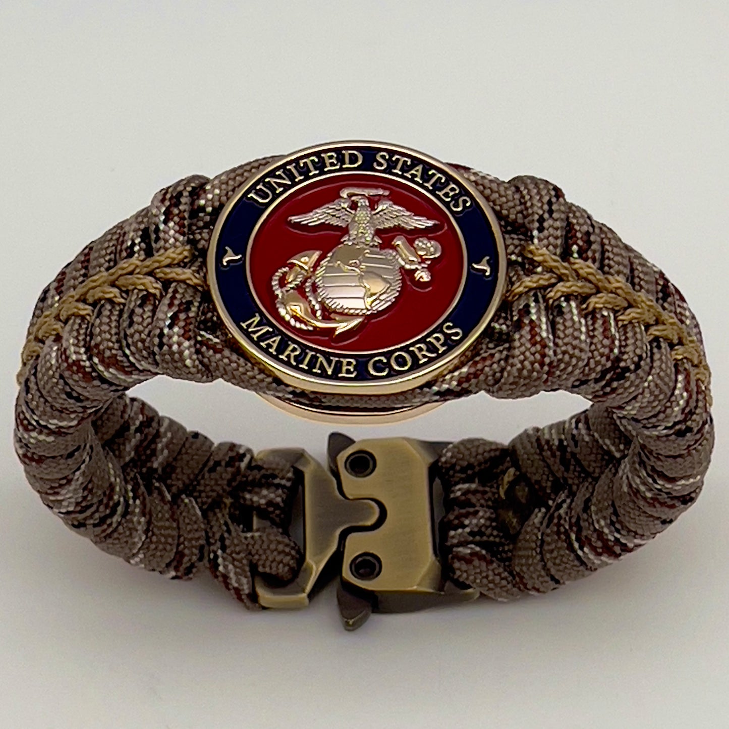 Thick and comfortable braided United States Marine Corps bracelet featuring a 24K gold and silver plated USMC officer Eagle Globe and Anchor medallion, a Cobra style tactical buckle and woven with Desert Camo 550 paracord gold micro cord.
