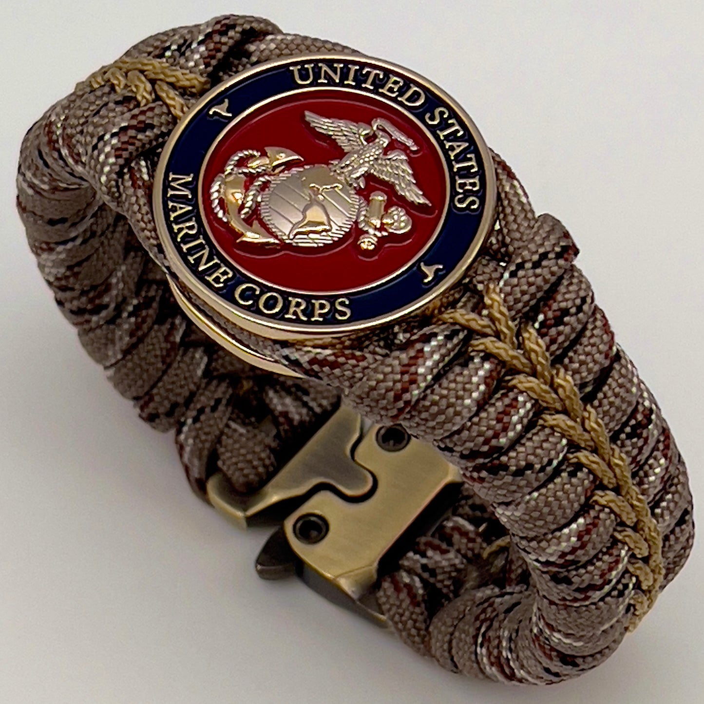 Thick and comfortable braided United States Marine Corps bracelet featuring a 24K gold and silver plated USMC officer Eagle Globe and Anchor medallion, a Cobra style tactical buckle and woven with Desert Camo 550 paracord gold micro cord.