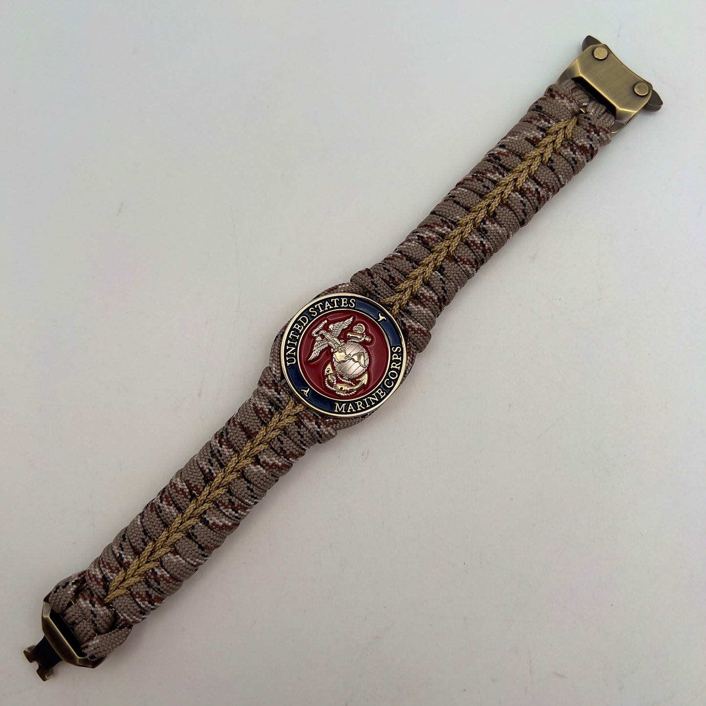 Thick and comfortable braided United States Marine Corps bracelet featuring a 24K gold and silver plated USMC officer Eagle Globe and Anchor medallion, a Cobra style tactical buckle and woven with Desert Camo 550 paracord gold micro cord.
