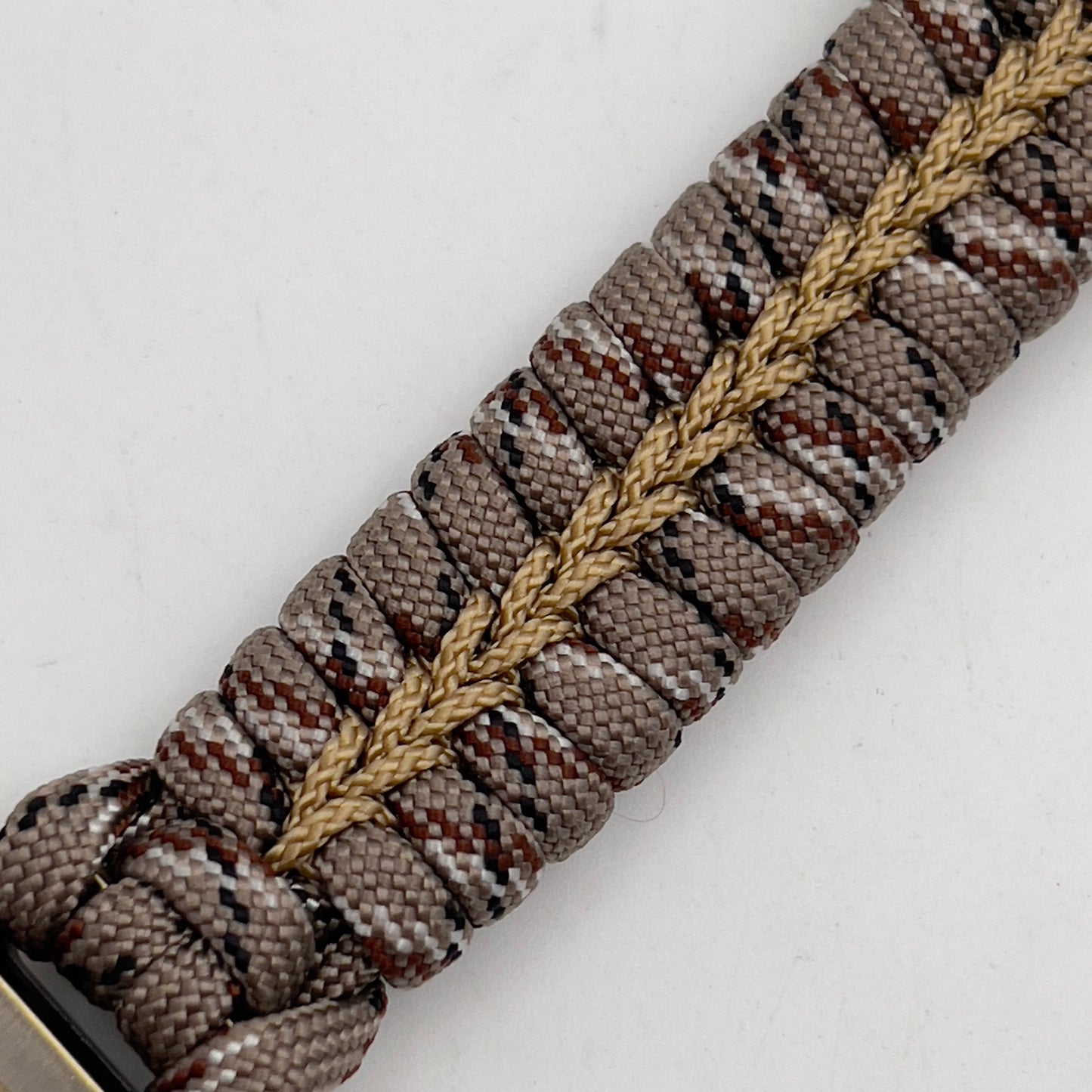 Thick and comfortable braided United States Marine Corps bracelet featuring a 24K gold and silver plated USMC officer Eagle Globe and Anchor medallion, a Cobra style tactical buckle and woven with Desert Camo 550 paracord gold micro cord.