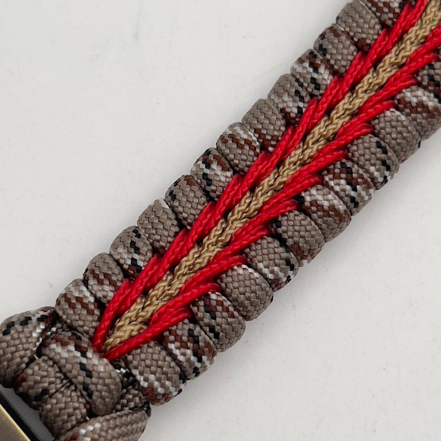 Thick and comfortable braided United States Marine Corps bracelet featuring a 24K gold and silver plated USMC officer Eagle Globe and Anchor medallion, a Cobra style tactical buckle and woven with Desert Camo 550 paracord and Imperial red and gold micro cord.