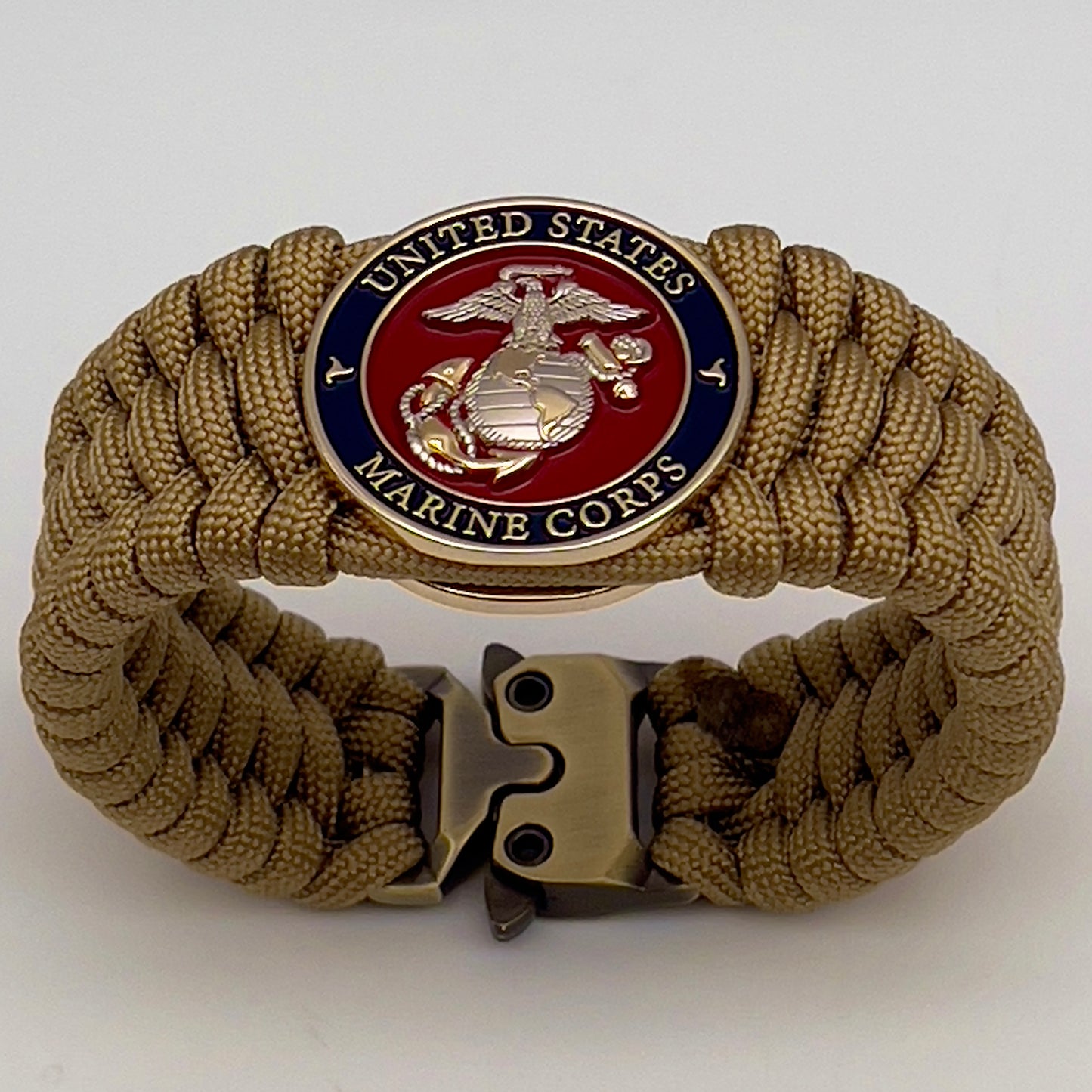 Thick and comfortable braided United States Marine Corps bracelet featuring a 24K gold and silver plated USMC officer Eagle Globe and Anchor medallion, a Cobra style tactical buckle and woven with gold 550 paracord.