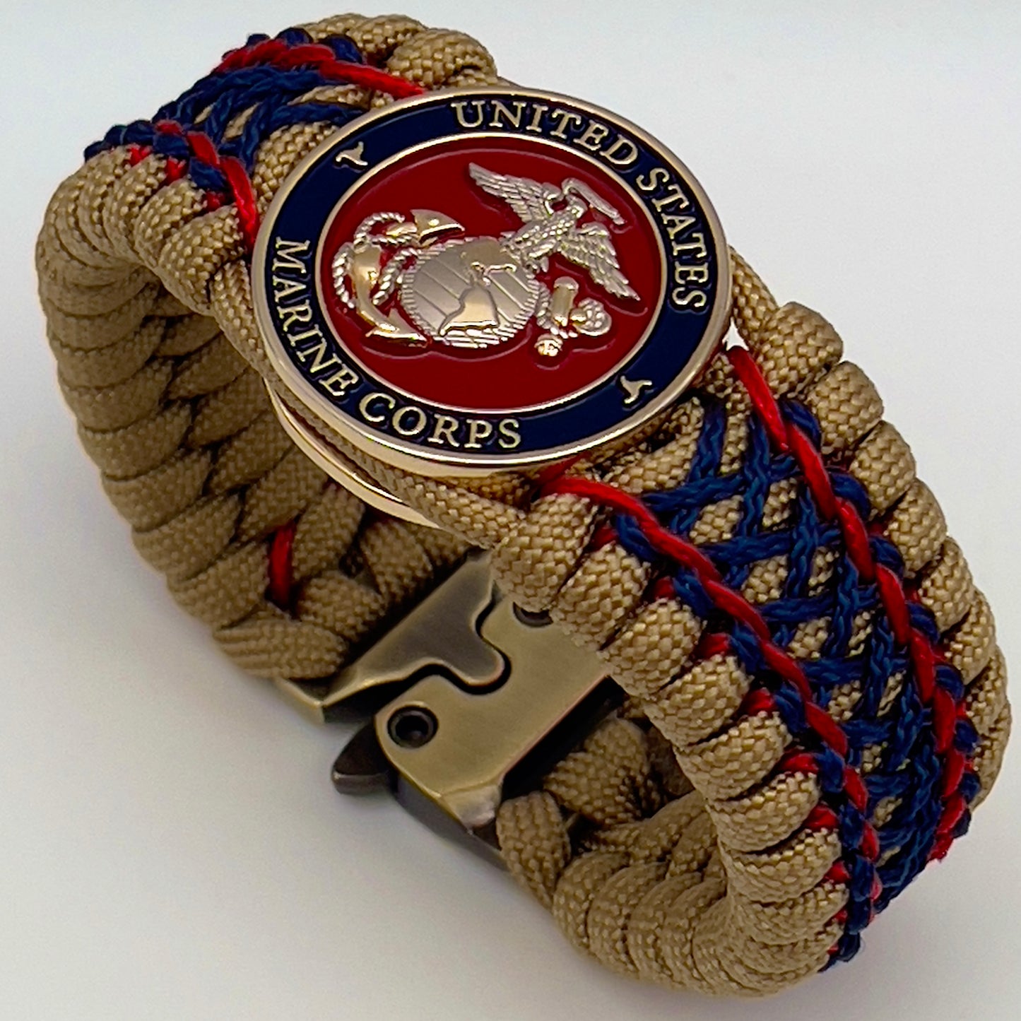 Thick and comfortable braided United States Marine Corps bracelet featuring a 24K gold and silver plated USMC officer Eagle Globe and Anchor medallion, a gold Cobra style tactical buckle and woven with gold 550 paracord and Imperial Red and Navy Blue micro cord.