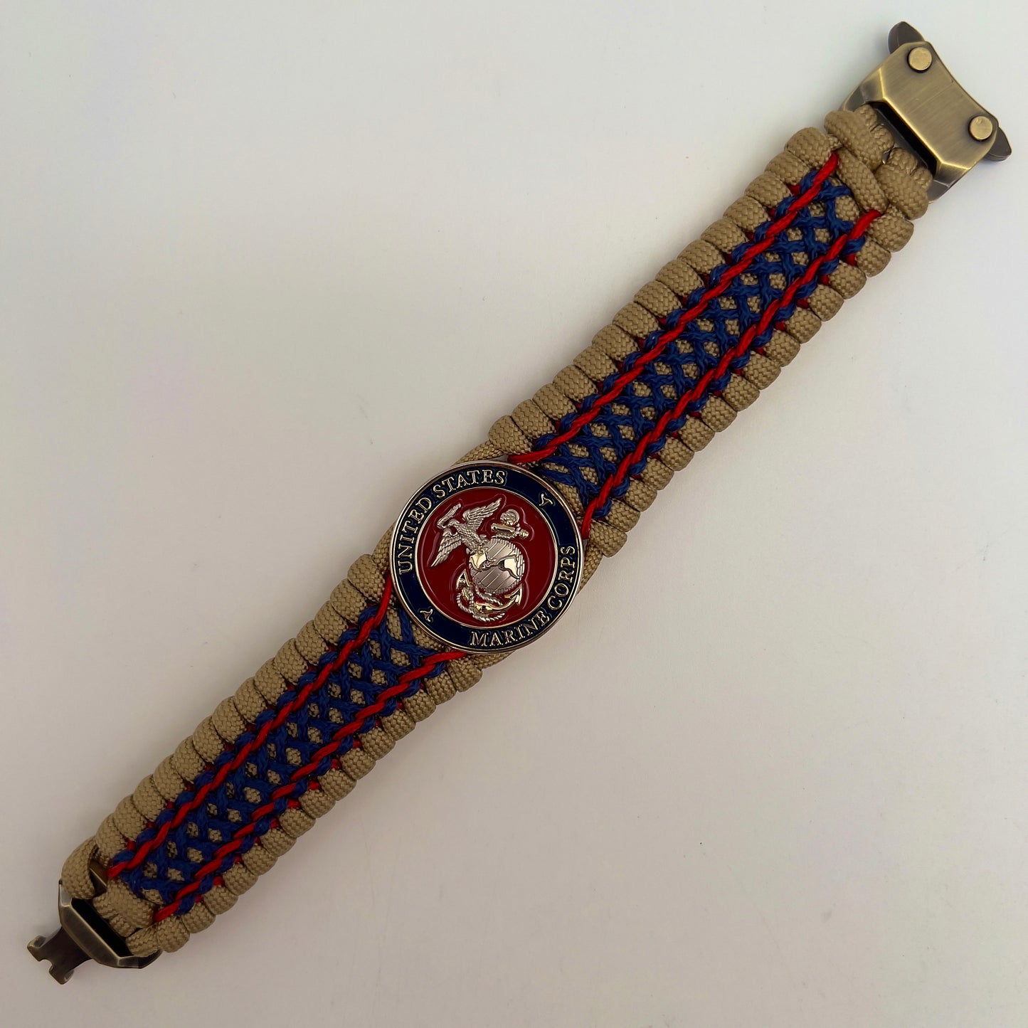 Thick and comfortable braided United States Marine Corps bracelet featuring a 24K gold and silver plated USMC officer Eagle Globe and Anchor medallion, a gold Cobra style tactical buckle and woven with gold 550 paracord and Imperial Red and Navy Blue micro cord.