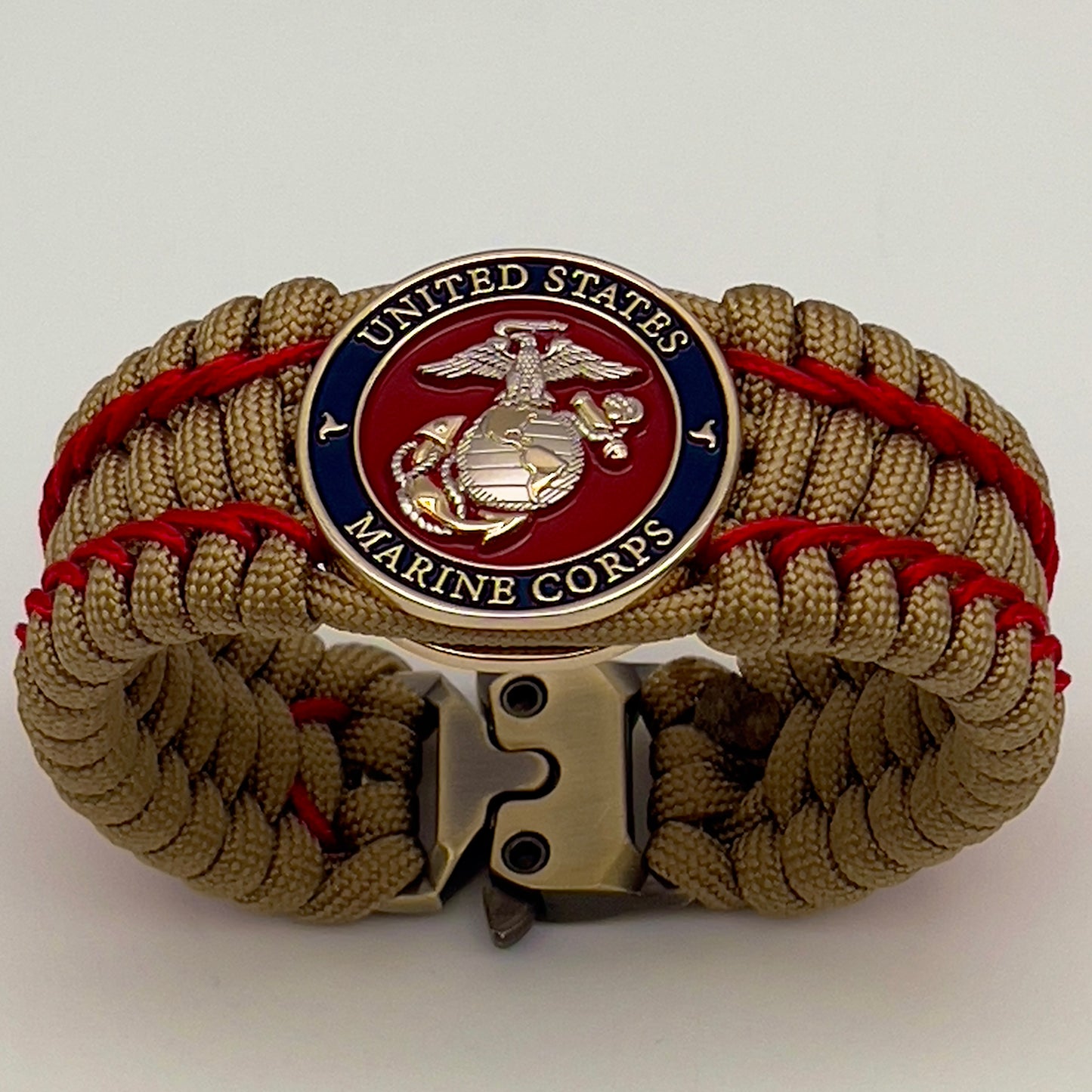 Thick and comfortable braided United States Marine Corps bracelet featuring a 24K gold and silver plated USMC officer Eagle Globe and Anchor medallion, a gold Cobra style tactical buckle and woven with gold 550 paracord and Imperial Red micro cord.