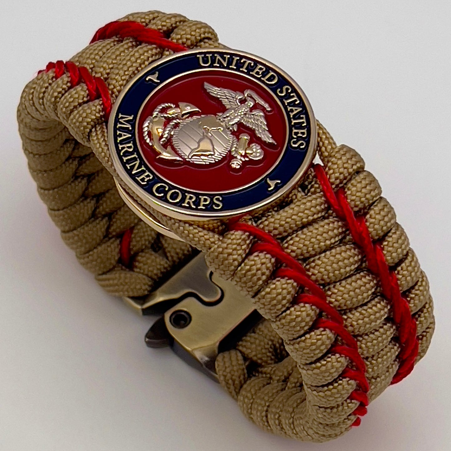 Thick and comfortable braided United States Marine Corps bracelet featuring a 24K gold and silver plated USMC officer Eagle Globe and Anchor medallion, a gold Cobra style tactical buckle and woven with gold 550 paracord and Imperial Red micro cord.