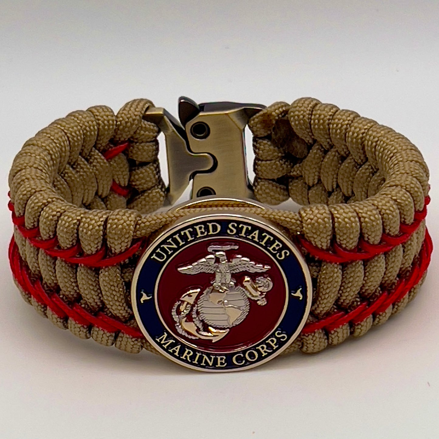 Thick and comfortable braided United States Marine Corps bracelet featuring a 24K gold and silver plated USMC officer Eagle Globe and Anchor medallion, a gold Cobra style tactical buckle and woven with gold 550 paracord and Imperial Red micro cord.