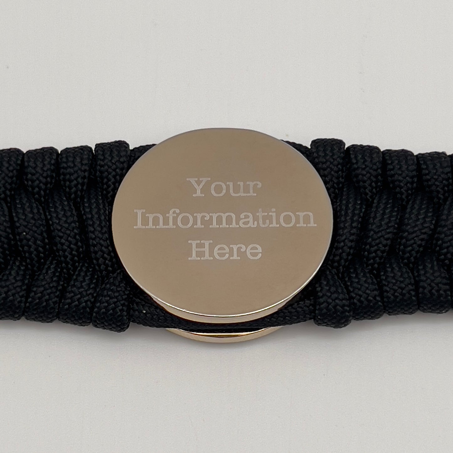 Thick and comfortable braided United States Marine Corps bracelet featuring a 24K gold and silver plated USMC officer Eagle Globe and Anchor medallion, a black Cobra style tactical buckle and woven with black 550 paracord.