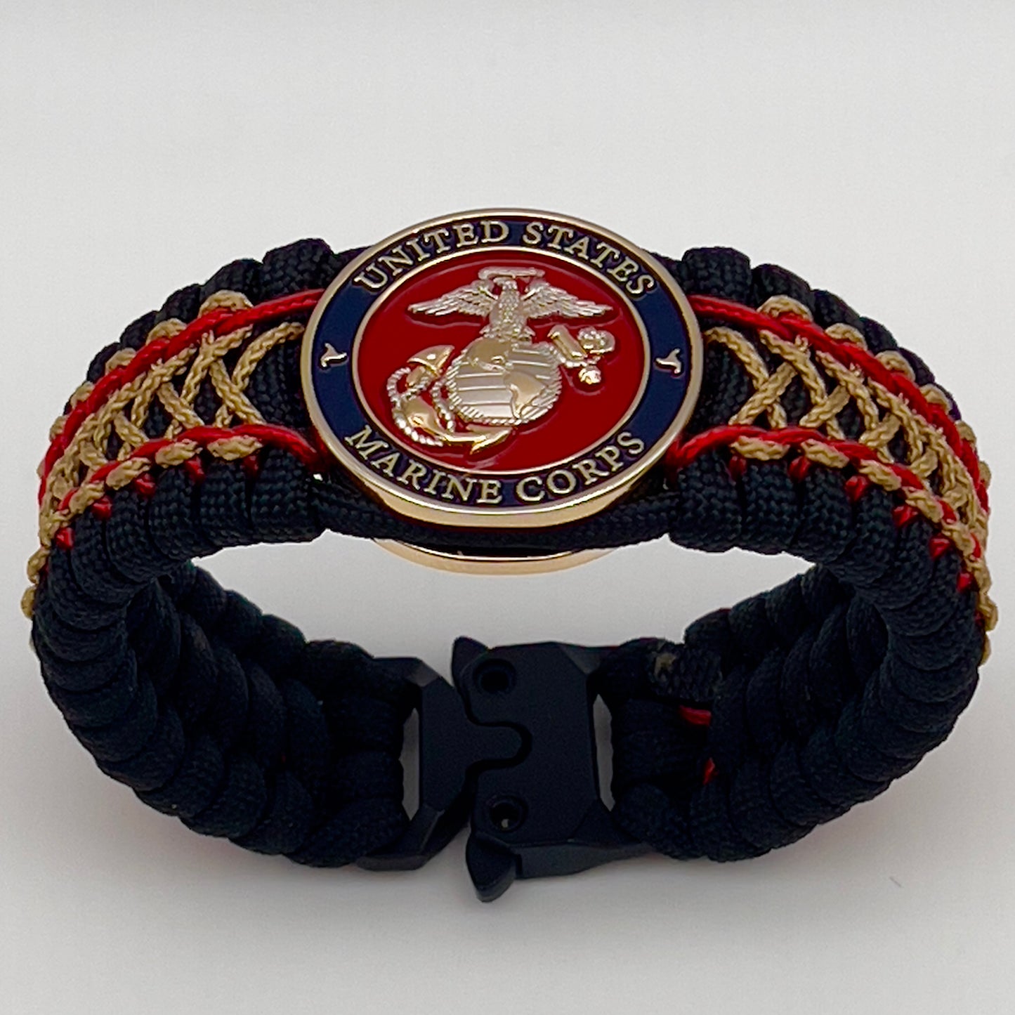 Thick and comfortable braided United States Marine Corps bracelet featuring a 24K gold and silver plated USMC officer Eagle Globe and Anchor medallion, a black Cobra style tactical buckle and woven with black 550 paracord and Imperial Red and gold micro cord.