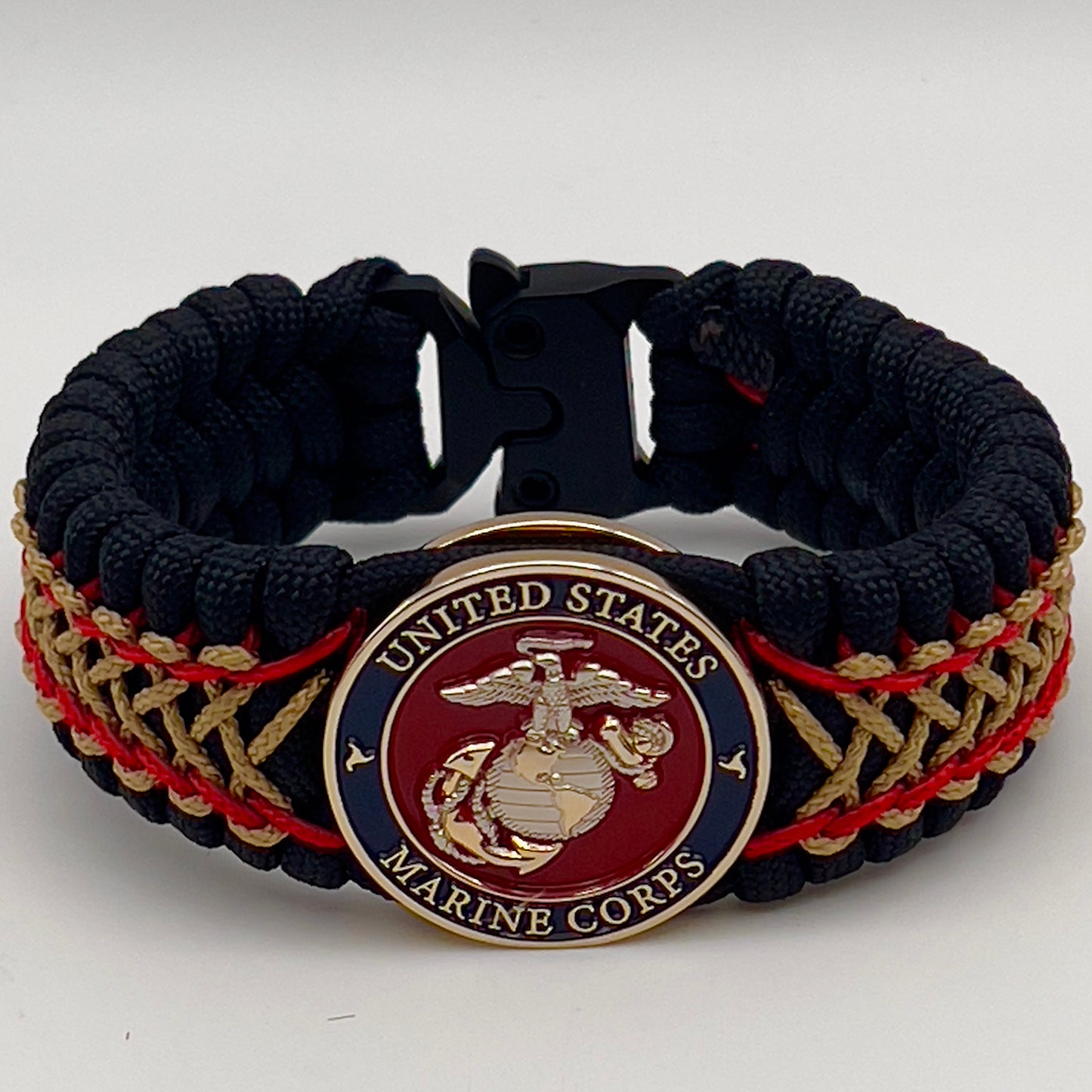 Thick and comfortable braided United States Marine Corps bracelet featuring a 24K gold and silver plated USMC officer Eagle Globe and Anchor medallion, a black Cobra style tactical buckle and woven with black 550 paracord and Imperial Red and gold micro cord.