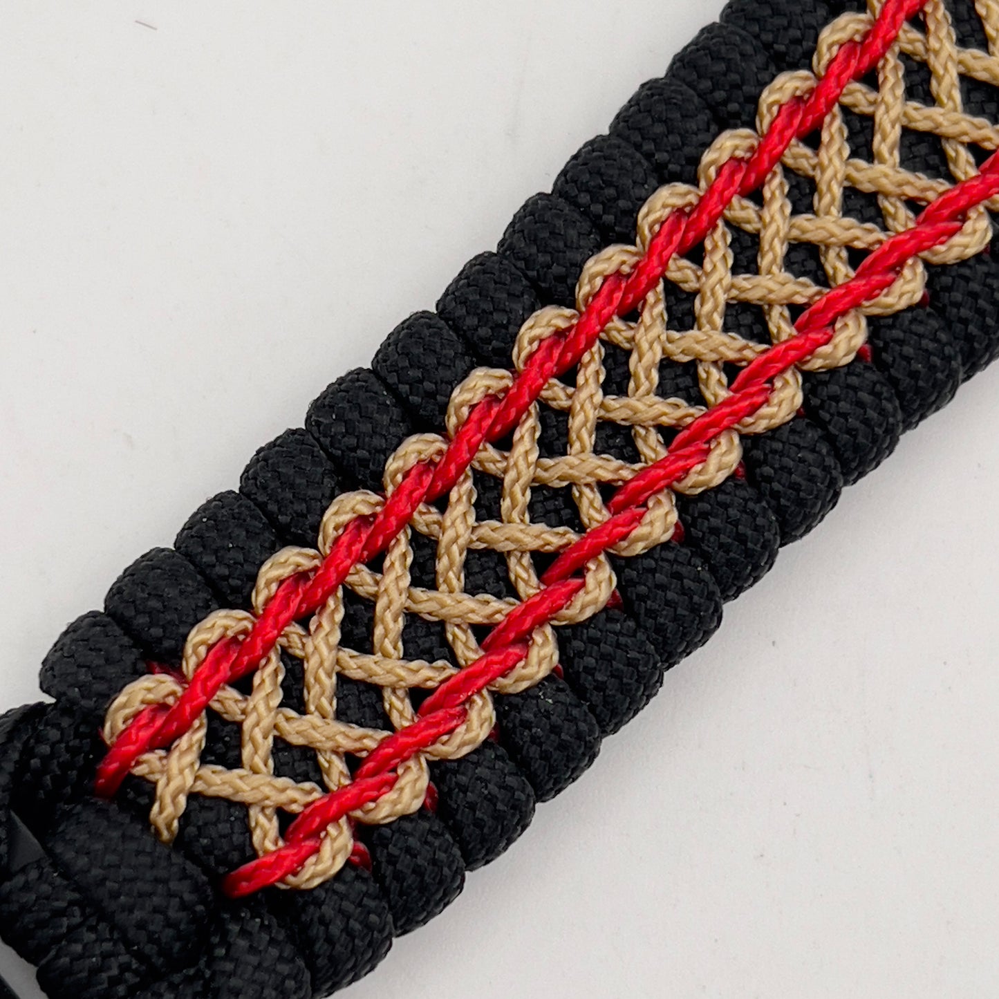 Thick and comfortable braided United States Marine Corps bracelet featuring a 24K gold and silver plated USMC officer Eagle Globe and Anchor medallion, a black Cobra style tactical buckle and woven with black 550 paracord and Imperial Red and gold micro cord.