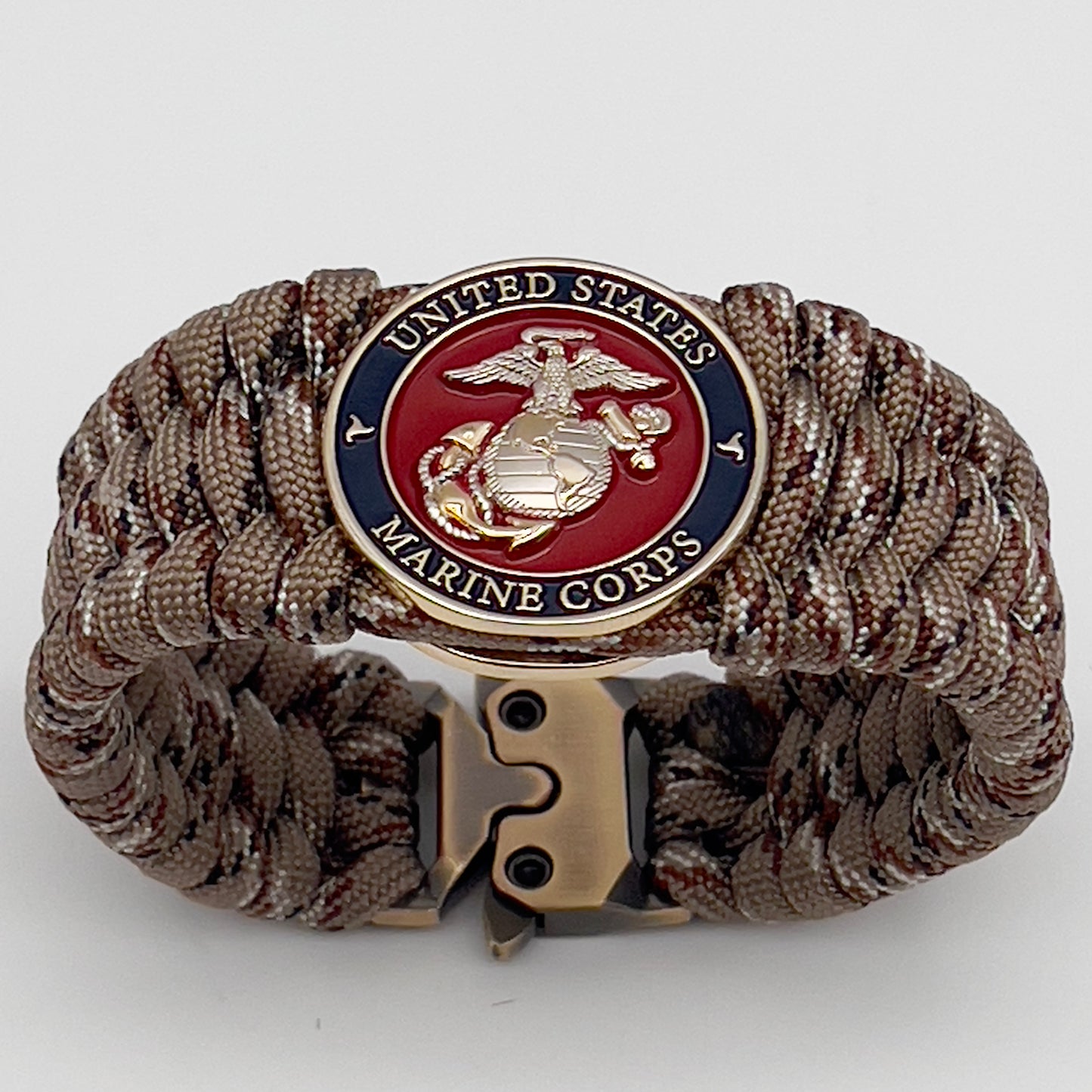 Thick and comfortable braided United States Marine Corps bracelet featuring a 24K gold and silver plated USMC officer Eagle Globe and Anchor medallion, a gold Cobra style tactical buckle and woven with Desert Camo 550 paracord.