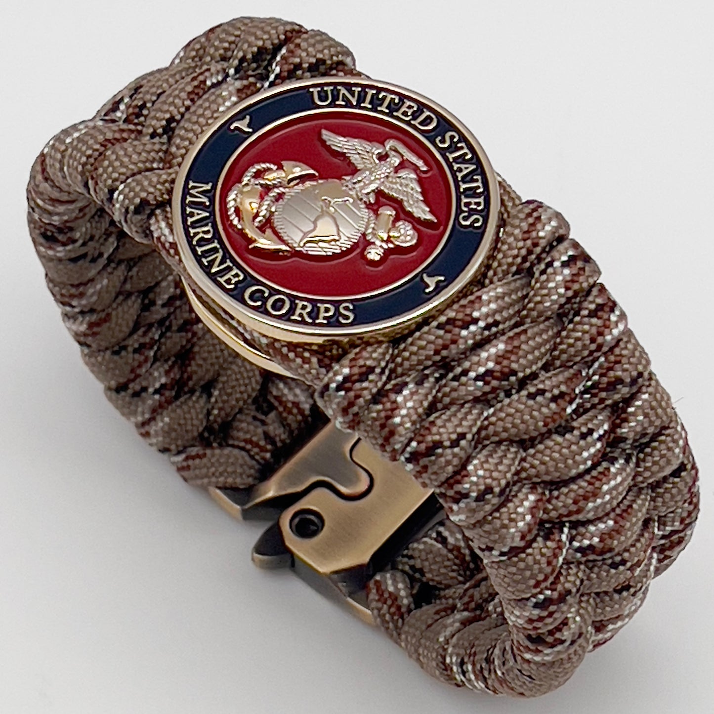 Thick and comfortable braided United States Marine Corps bracelet featuring a 24K gold and silver plated USMC officer Eagle Globe and Anchor medallion, a gold Cobra style tactical buckle and woven with Desert Camo 550 paracord.