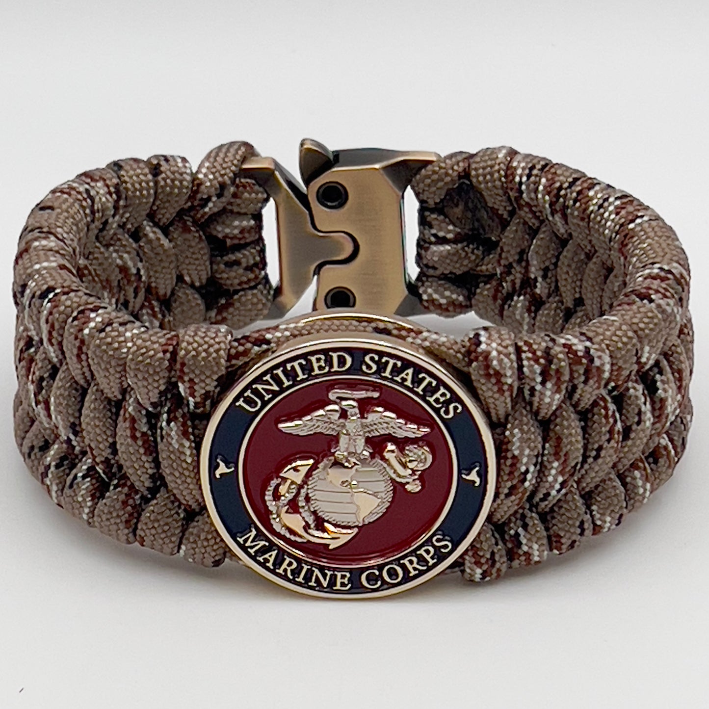 Thick and comfortable braided United States Marine Corps bracelet featuring a 24K gold and silver plated USMC officer Eagle Globe and Anchor medallion, a gold Cobra style tactical buckle and woven with Desert Camo 550 paracord.