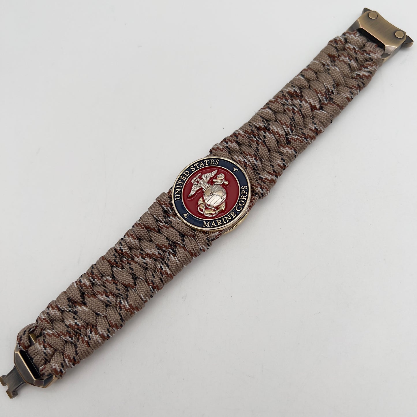 Thick and comfortable braided United States Marine Corps bracelet featuring a 24K gold and silver plated USMC officer Eagle Globe and Anchor medallion, a gold Cobra style tactical buckle and woven with Desert Camo 550 paracord.