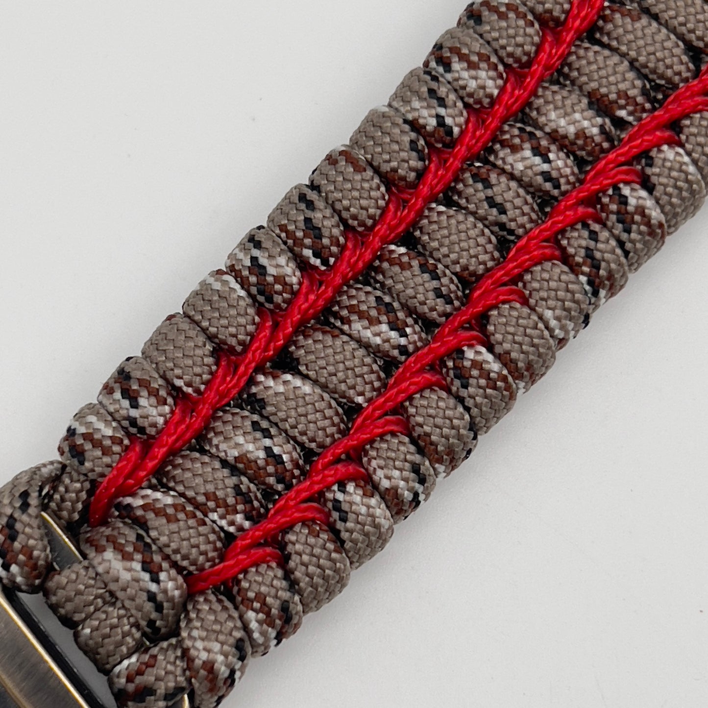 Thick and comfortable braided United States Marine Corps bracelet featuring a 24K gold and silver plated USMC officer Eagle Globe and Anchor medallion, a gold Cobra style tactical buckle and woven with Desert Camo 550 paracord and Imperial Red micro cord.