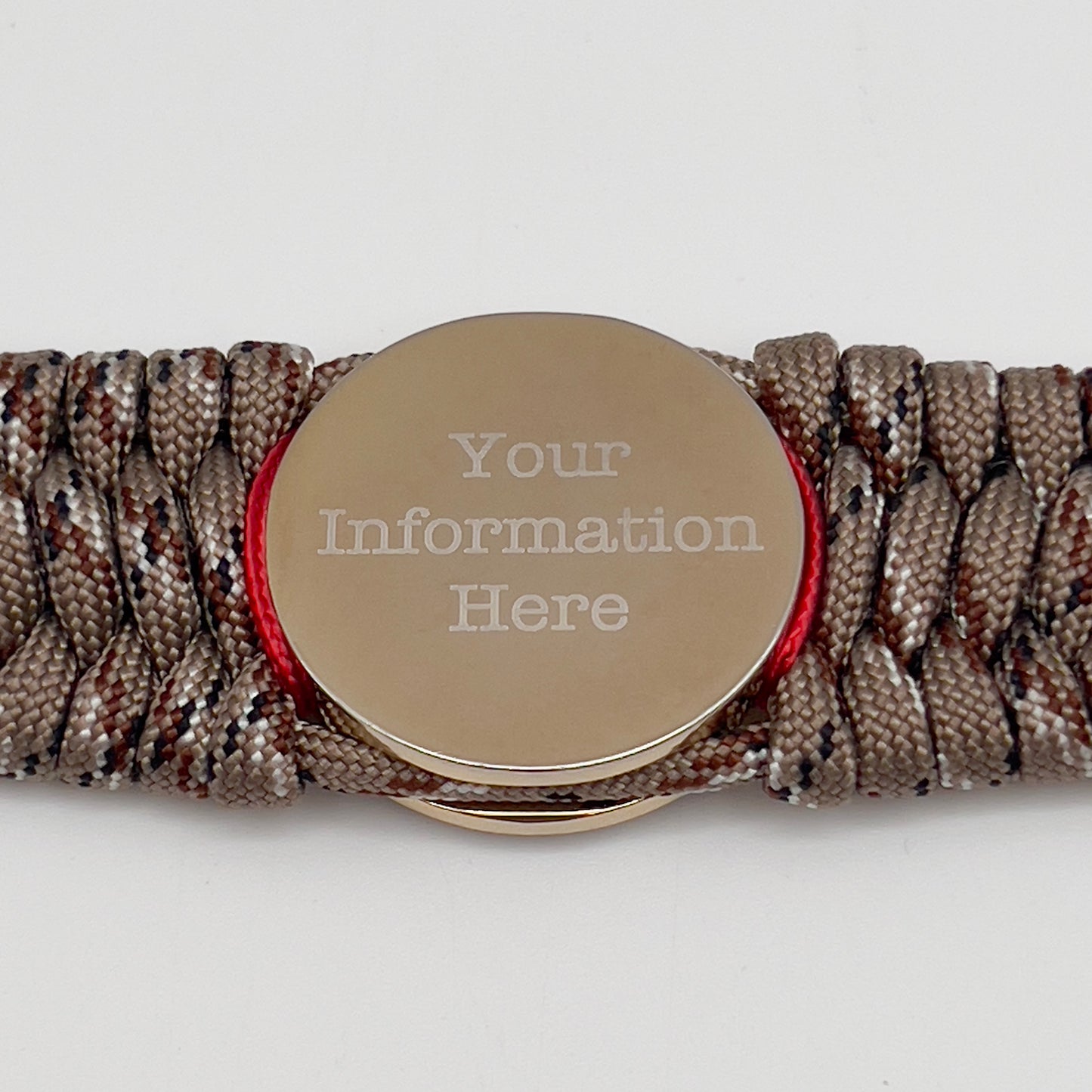 Thick and comfortable braided United States Marine Corps bracelet featuring a 24K gold and silver plated USMC officer Eagle Globe and Anchor medallion, a gold Cobra style tactical buckle and woven with Desert Camo 550 paracord and Imperial Red micro cord.