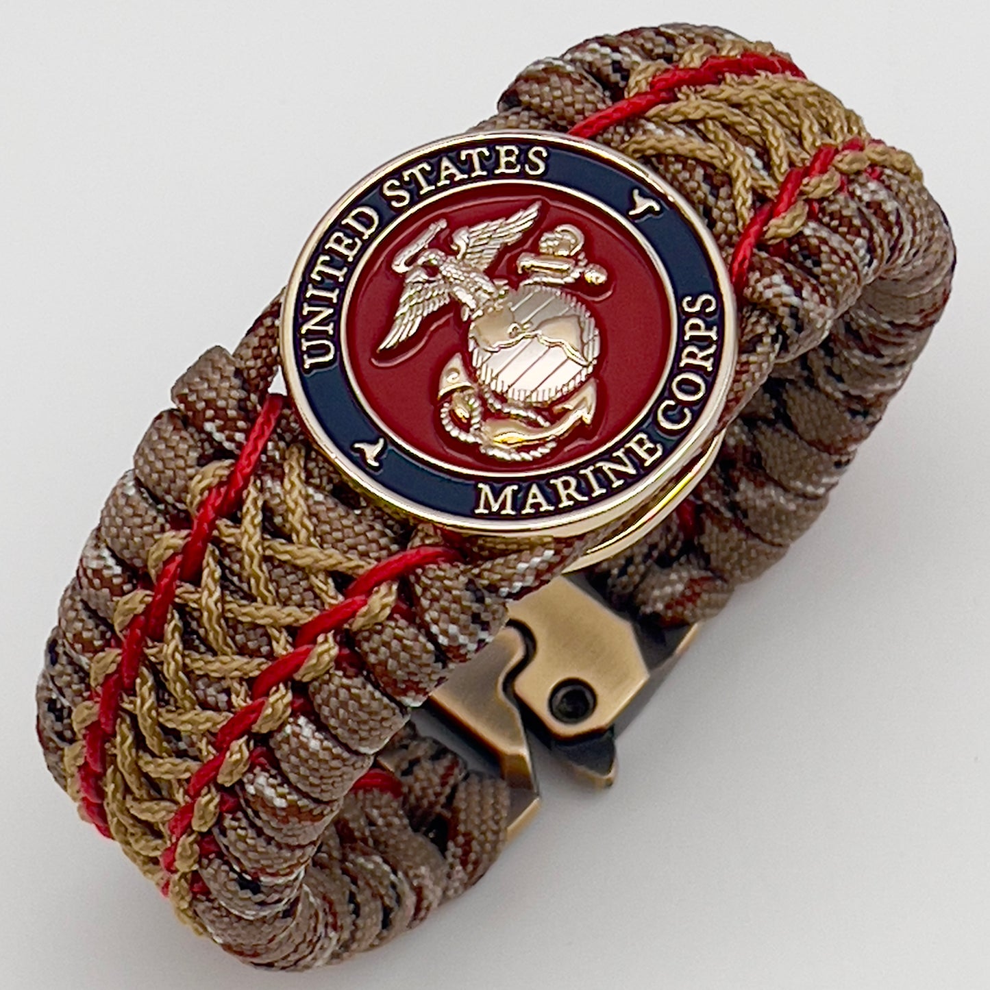 Thick and comfortable braided United States Marine Corps bracelet featuring a 24K gold and silver plated USMC officer Eagle Globe and Anchor medallion, a gold Cobra style tactical buckle and woven with Desert Camo 550 paracord and Imperial Red and Gold micro cord.