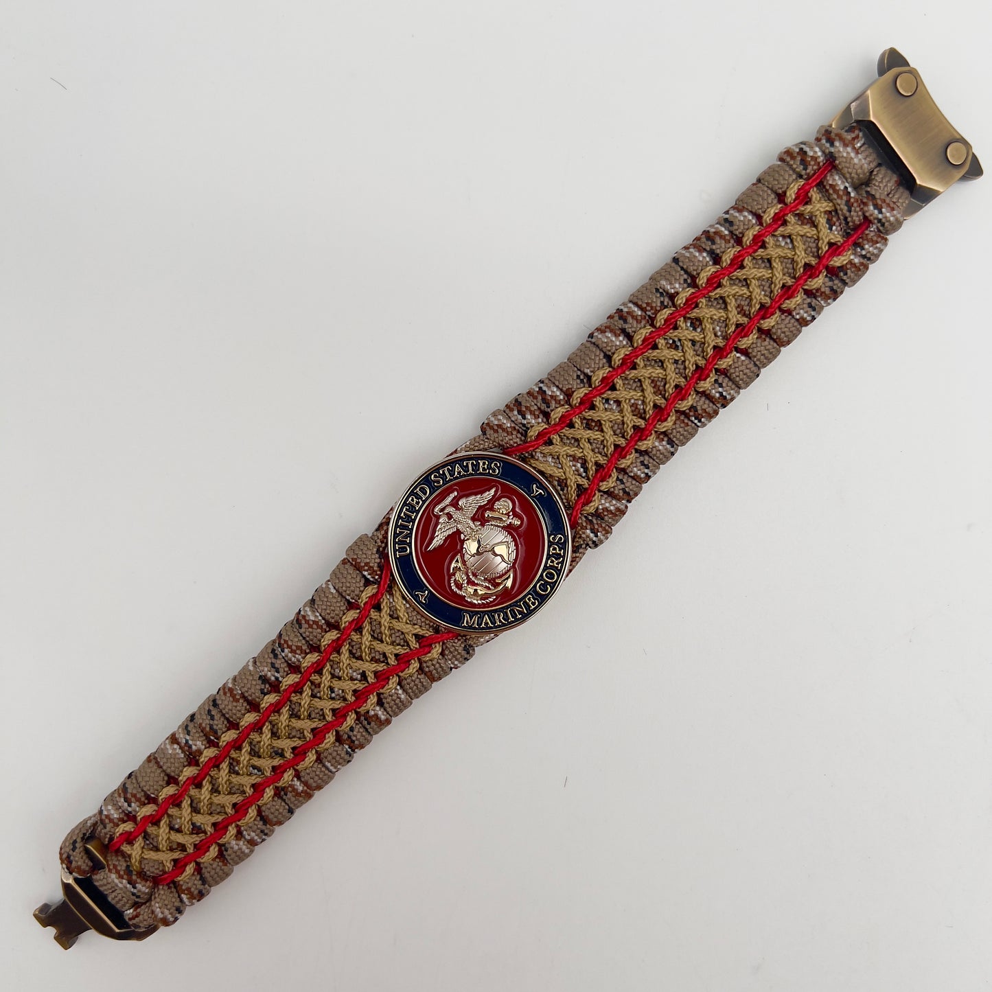 Thick and comfortable braided United States Marine Corps bracelet featuring a 24K gold and silver plated USMC officer Eagle Globe and Anchor medallion, a gold Cobra style tactical buckle and woven with Desert Camo 550 paracord and Imperial Red and Gold micro cord.