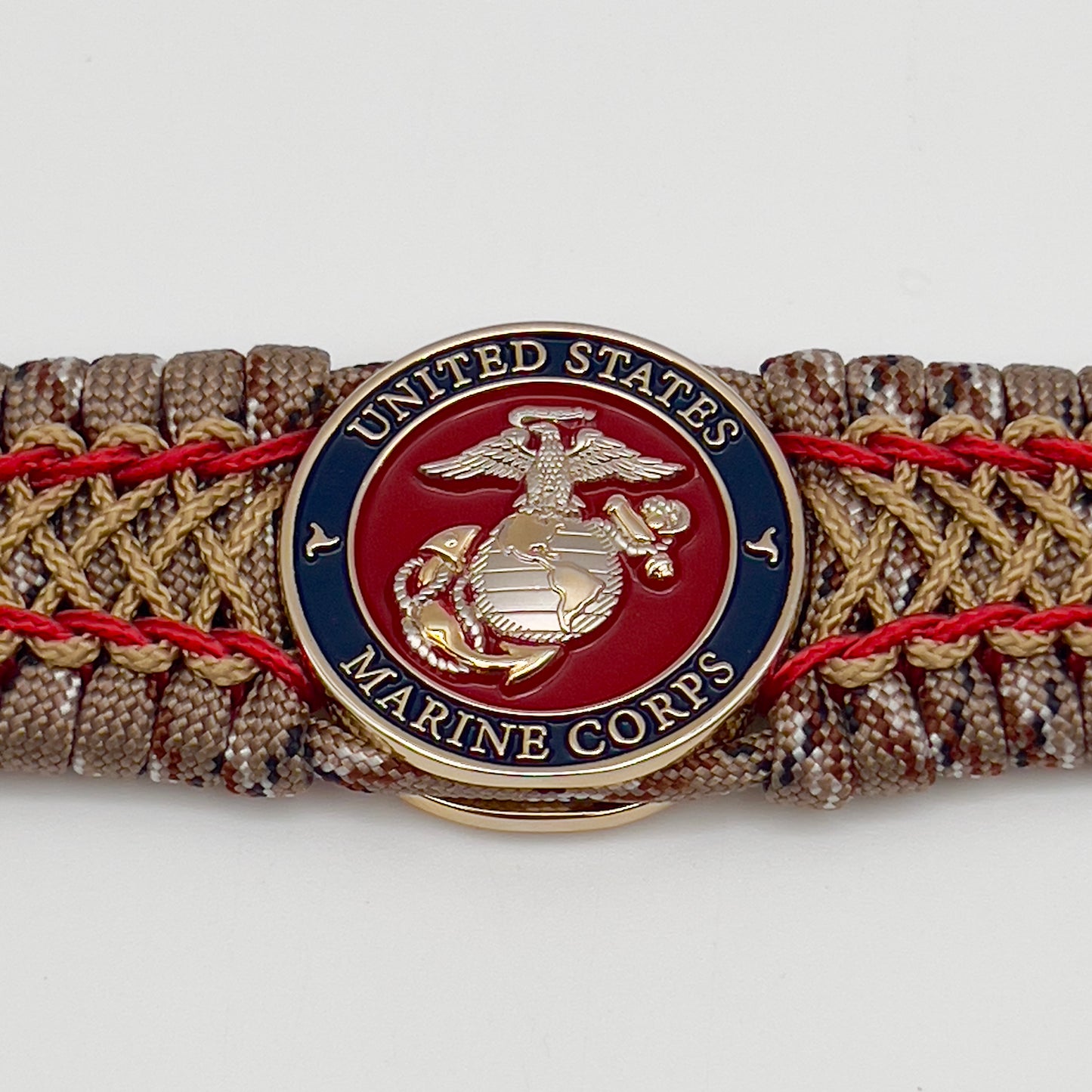 Thick and comfortable braided United States Marine Corps bracelet featuring a 24K gold and silver plated USMC officer Eagle Globe and Anchor medallion, a gold Cobra style tactical buckle and woven with Desert Camo 550 paracord and Imperial Red and Gold micro cord.