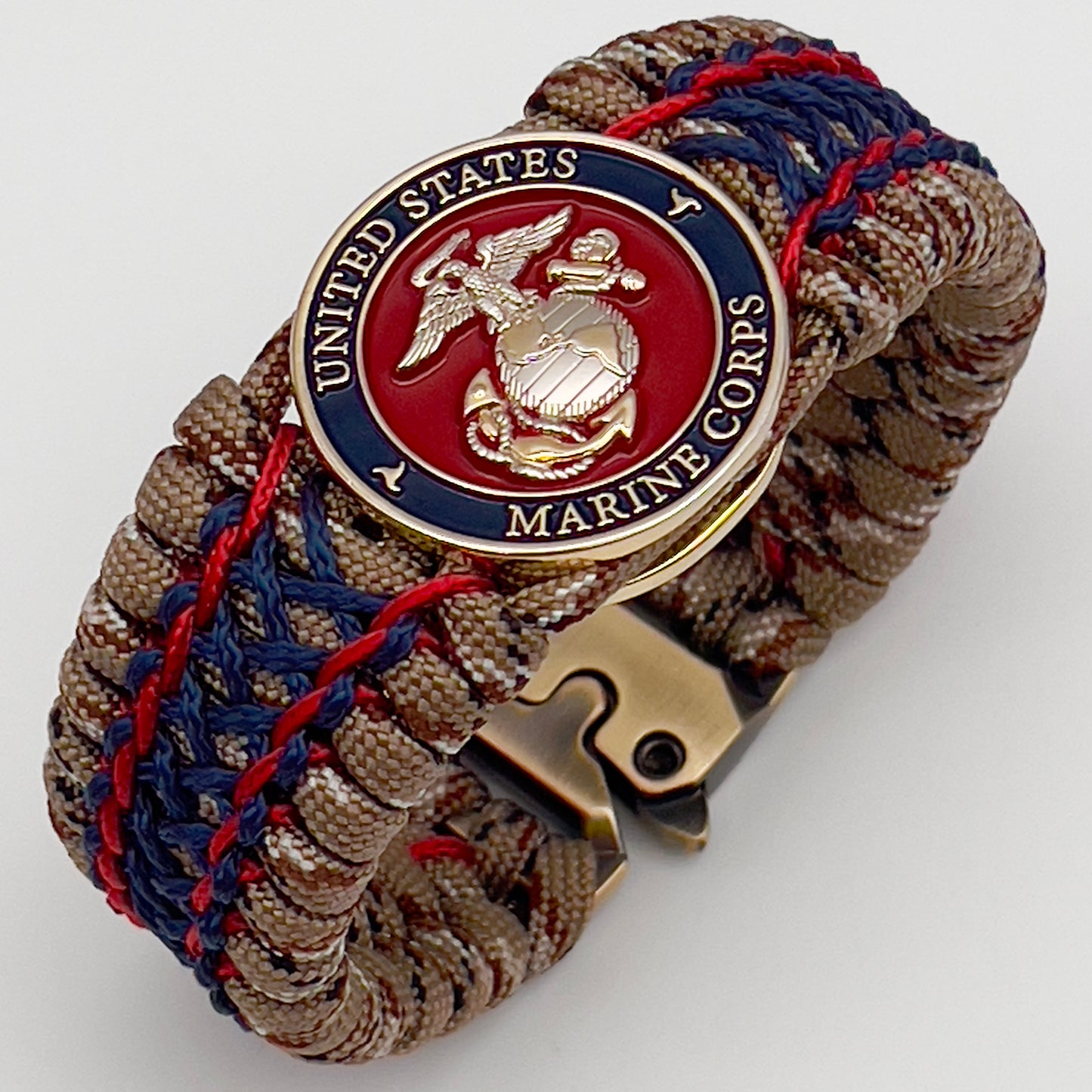 Thick and comfortable braided United States Marine Corps bracelet featuring a 24K gold and silver plated USMC officer Eagle Globe and Anchor medallion, a gold Cobra style tactical buckle and woven with Desert Camo 550 paracord and Imperial Red and Navy Blue micro cord.