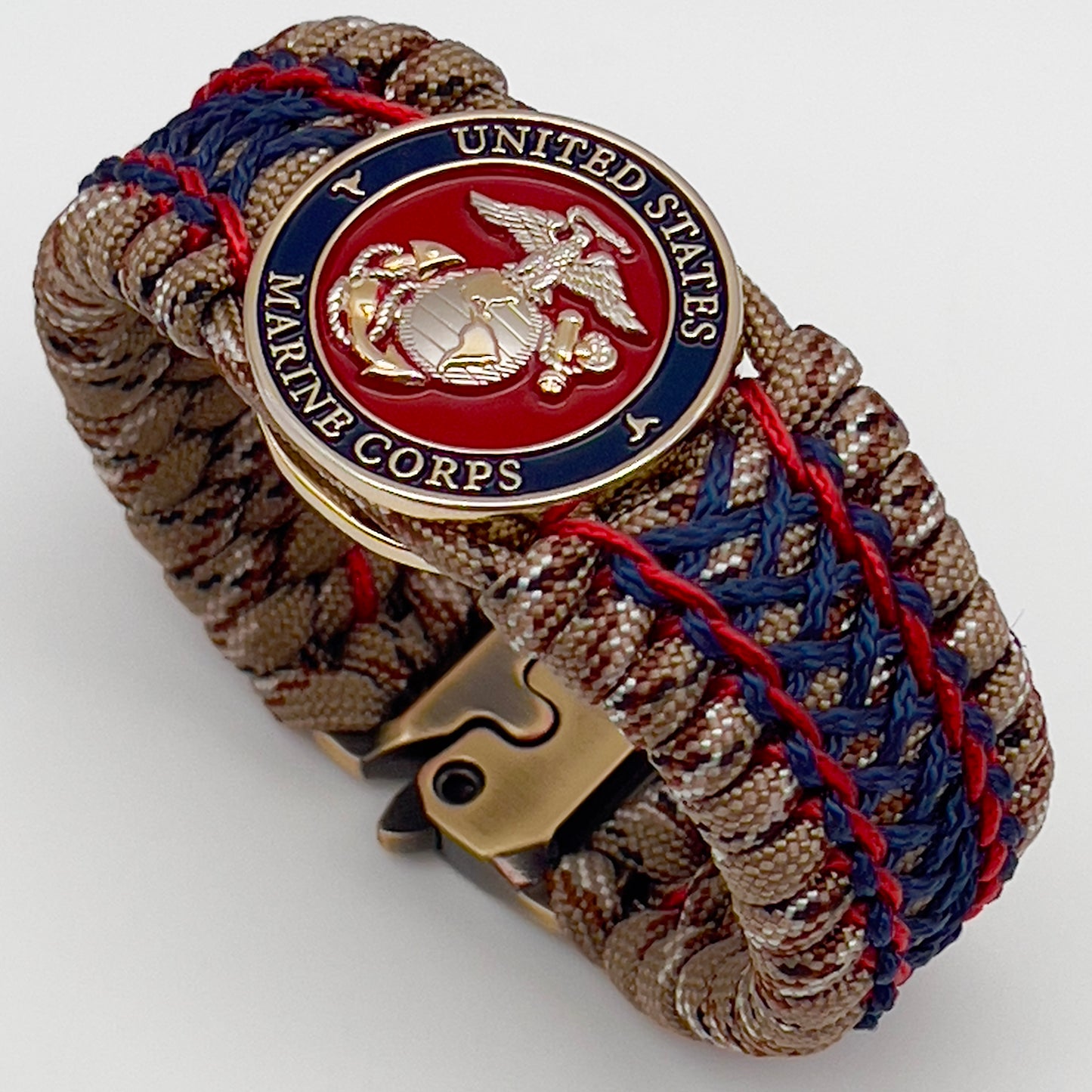 Thick and comfortable braided United States Marine Corps bracelet featuring a 24K gold and silver plated USMC officer Eagle Globe and Anchor medallion, a gold Cobra style tactical buckle and woven with Desert Camo 550 paracord and Imperial Red and Navy Blue micro cord.