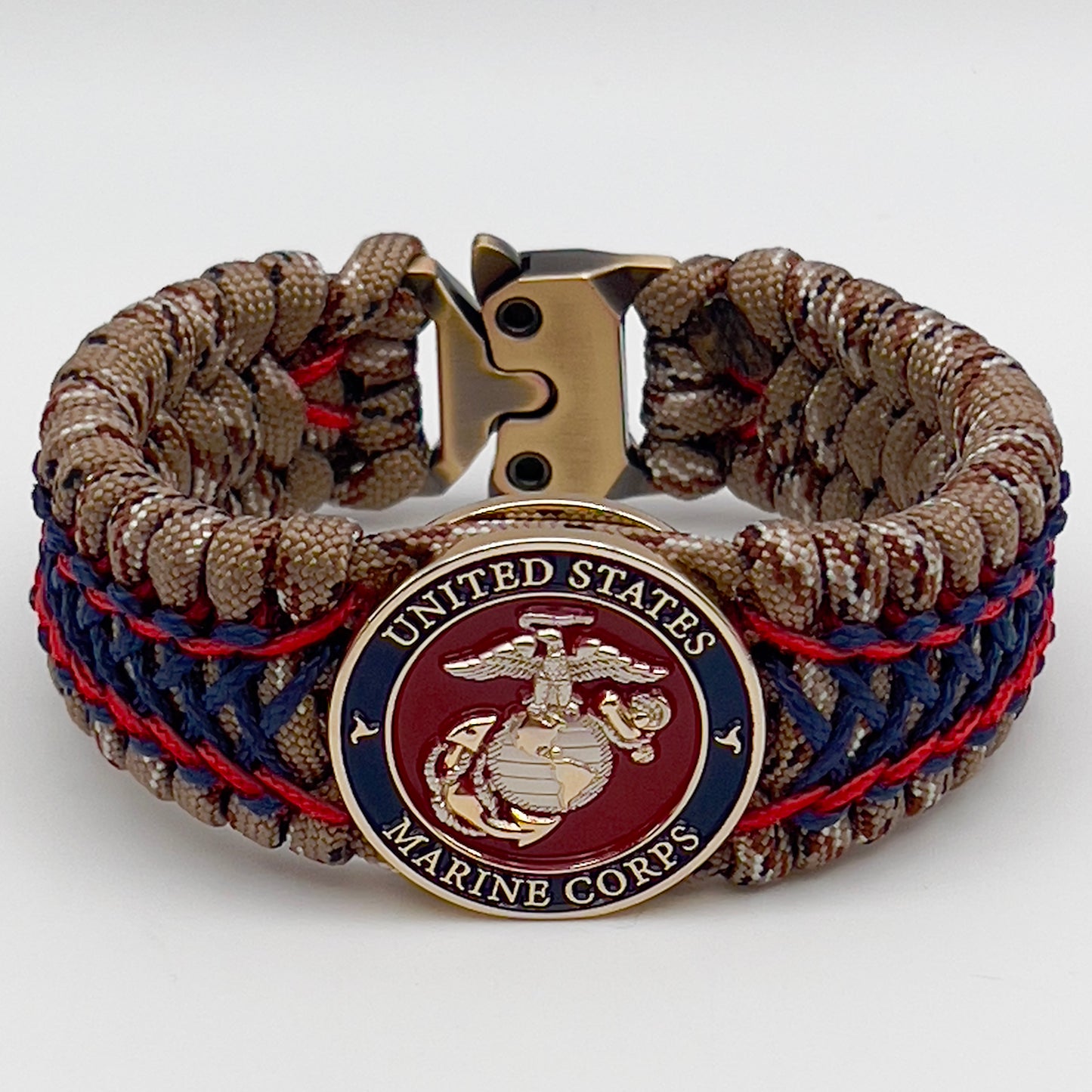 Thick and comfortable braided United States Marine Corps bracelet featuring a 24K gold and silver plated USMC officer Eagle Globe and Anchor medallion, a gold Cobra style tactical buckle and woven with Desert Camo 550 paracord and Imperial Red and Navy Blue micro cord.