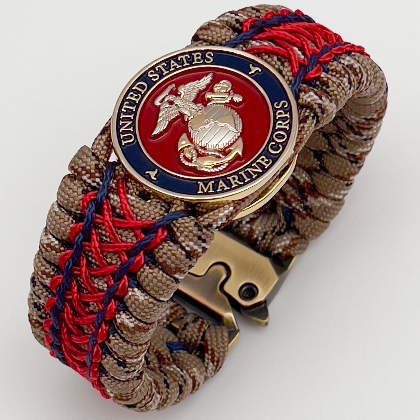 Thick and comfortable braided United States Marine Corps bracelet featuring a 24K gold and silver plated USMC officer Eagle Globe and Anchor medallion, a gold Cobra style tactical buckle and woven with Desert Camo 550 paracord and Imperial Red and Navy Blue micro cord.