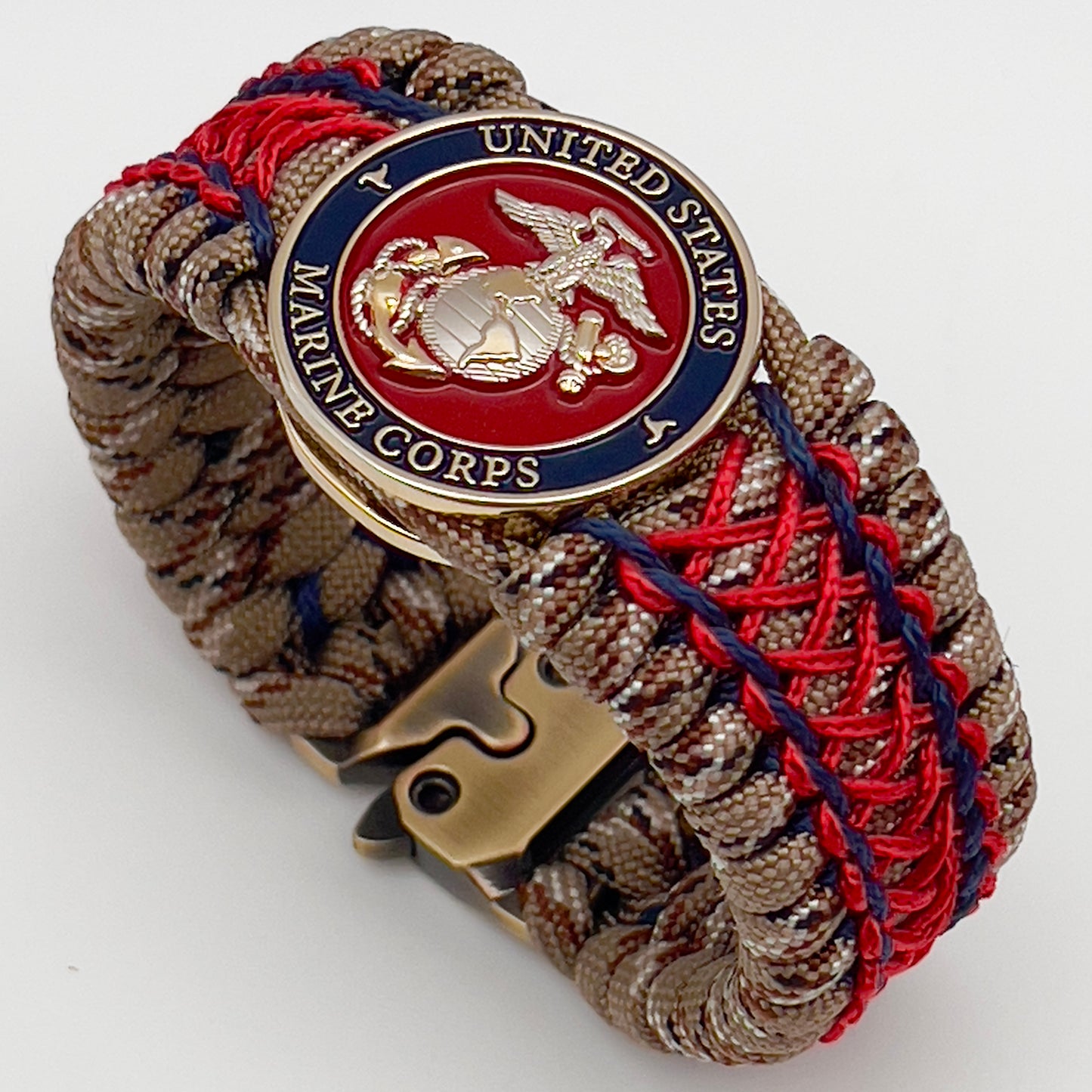 Thick and comfortable braided United States Marine Corps bracelet featuring a 24K gold and silver plated USMC officer Eagle Globe and Anchor medallion, a gold Cobra style tactical buckle and woven with Desert Camo 550 paracord and Imperial Red and Navy Blue micro cord.