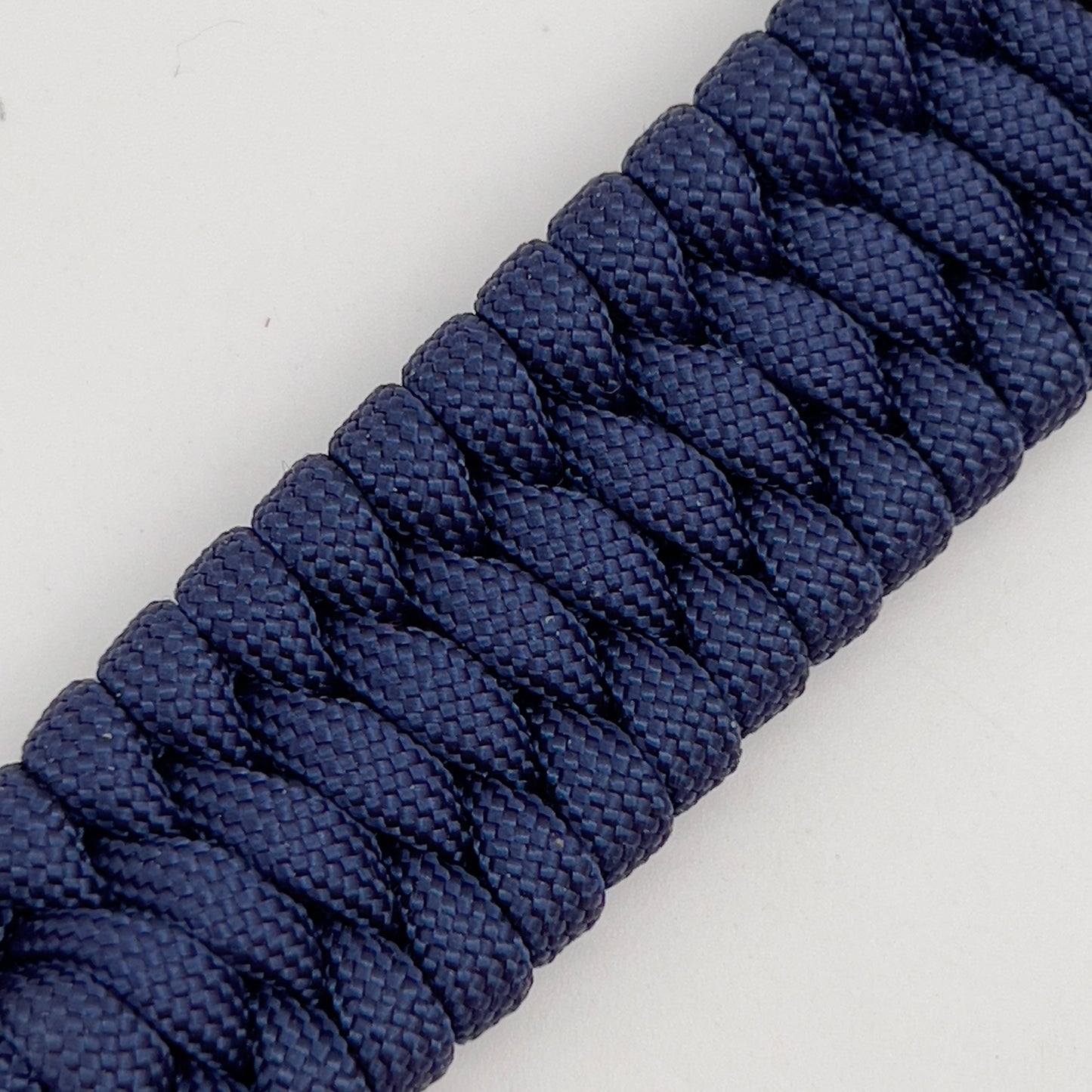 Thick and comfortable braided United States Marine Corps bracelet featuring a 24K gold and silver plated USMC officer Eagle Globe and Anchor medallion, a Cobra style tactical buckle and woven with Navy Blue 550 paracord.