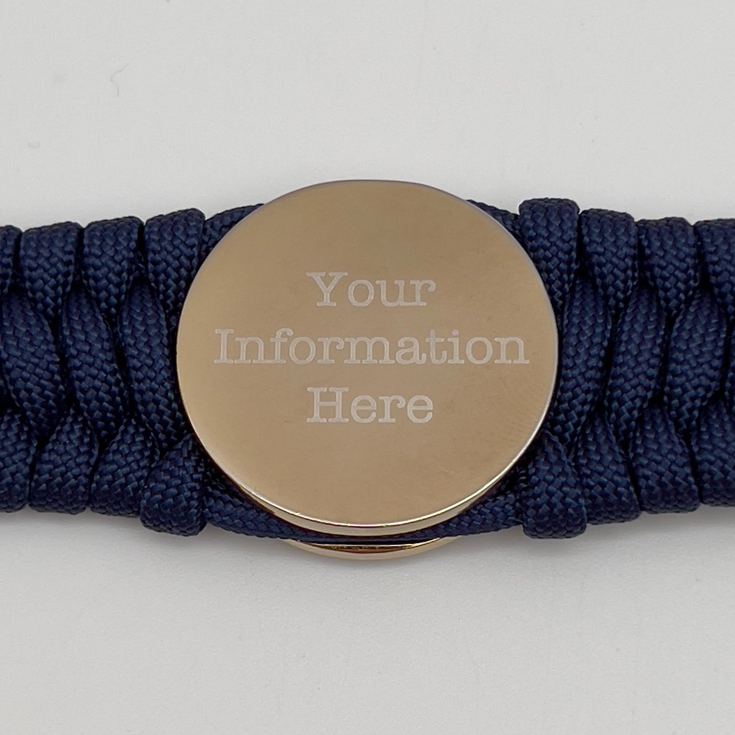 Thick and comfortable braided United States Marine Corps bracelet featuring a 24K gold and silver plated USMC officer Eagle Globe and Anchor medallion, a Cobra style tactical buckle and woven with Navy Blue 550 paracord.
