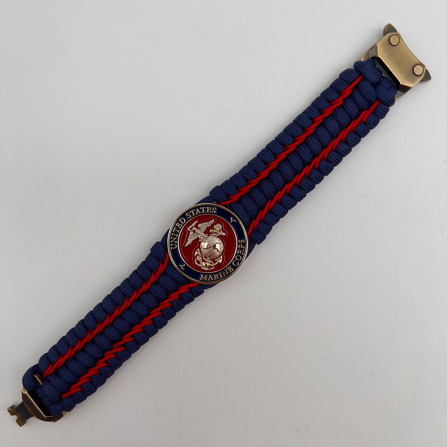 Thick and comfortable braided United States Marine Corps bracelet featuring a 24K gold and silver plated USMC officer Eagle Globe and Anchor medallion, a Cobra style tactical buckle and woven with gold 550 paracord and Imperial Red micro cord.